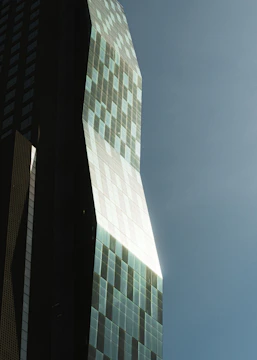 Modern skyscraper with geometric facade against blue sky