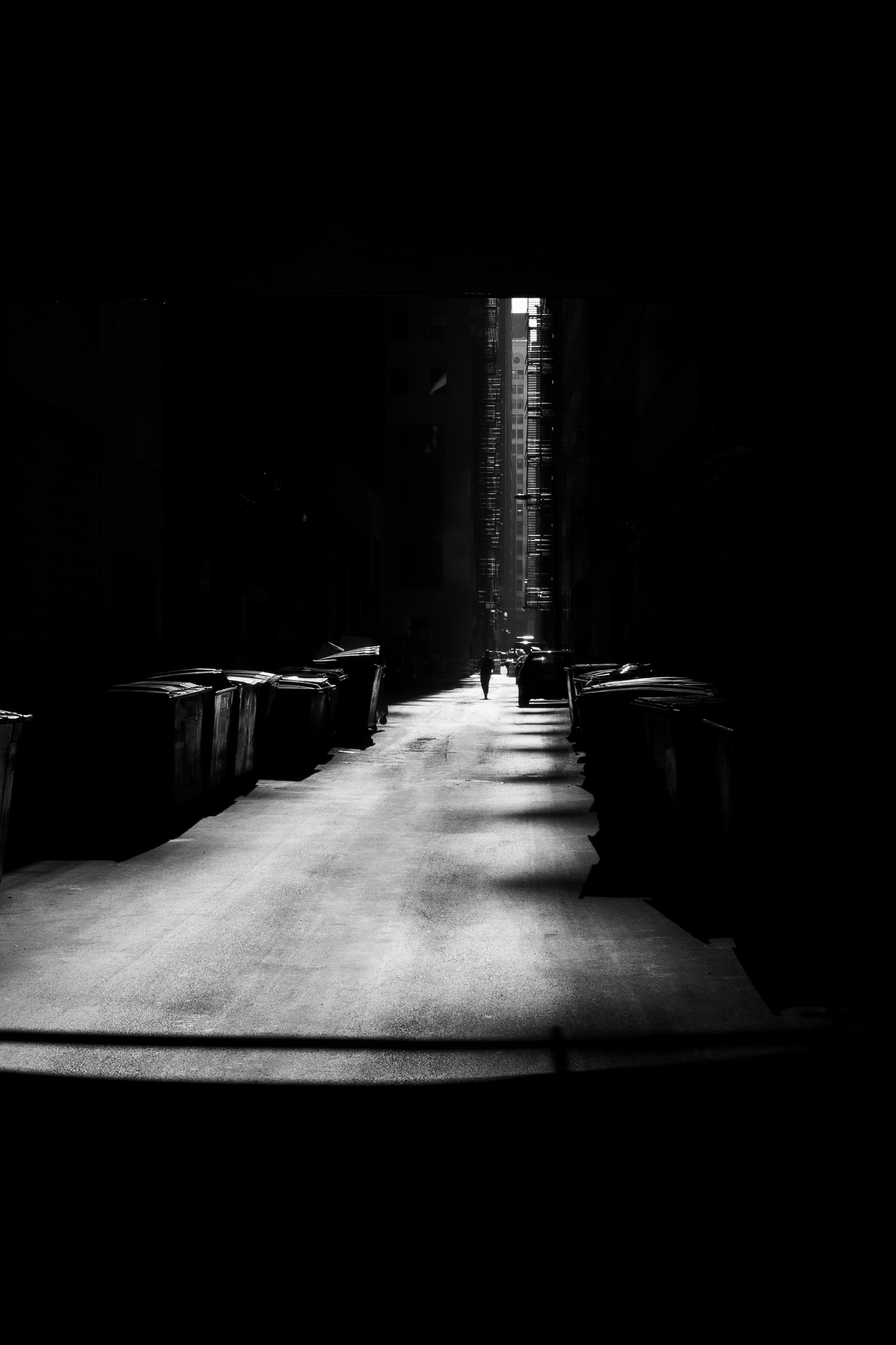 Dark alleyway with two figures walking away
