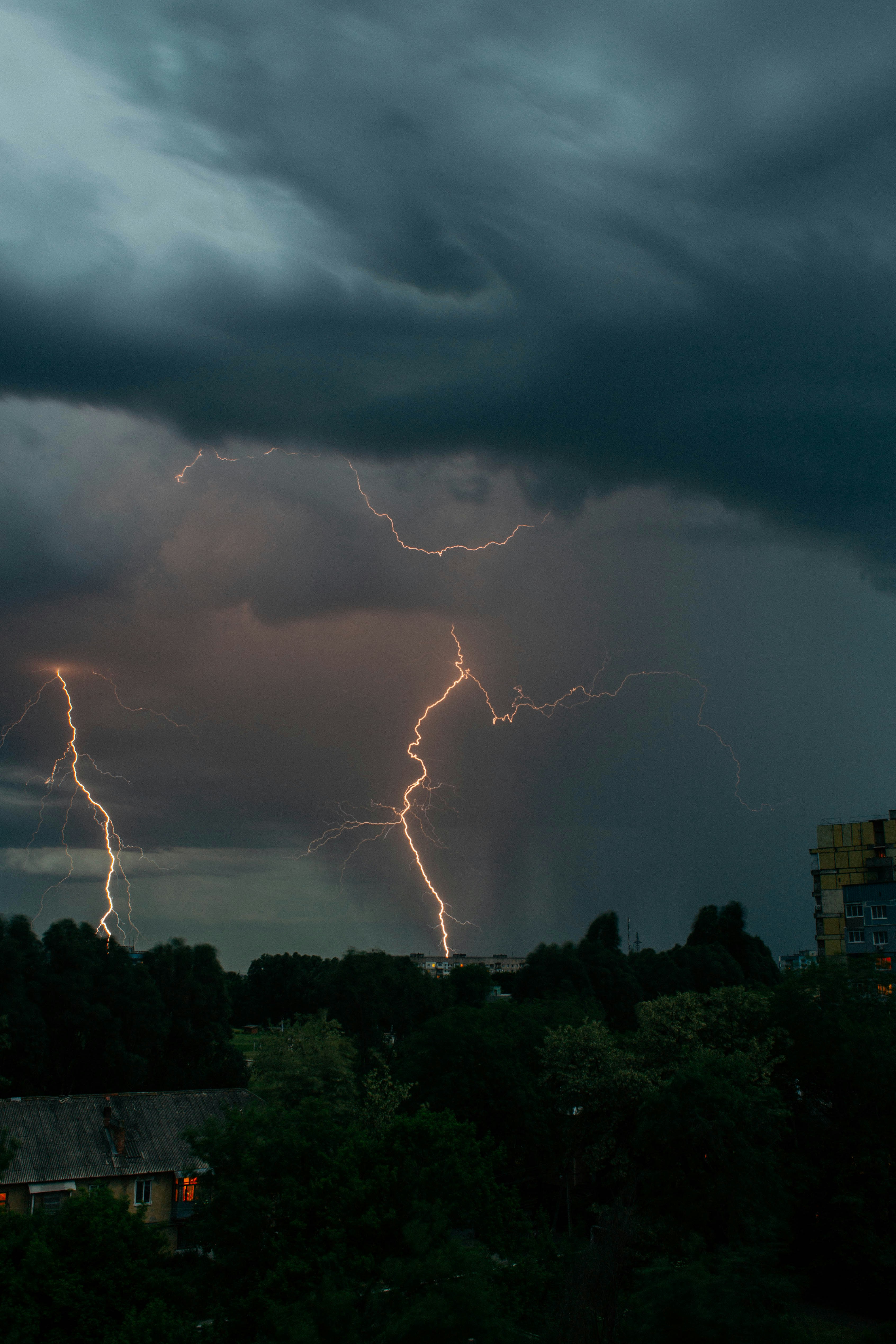 Lightning strikes illuminate the stormy night sky.