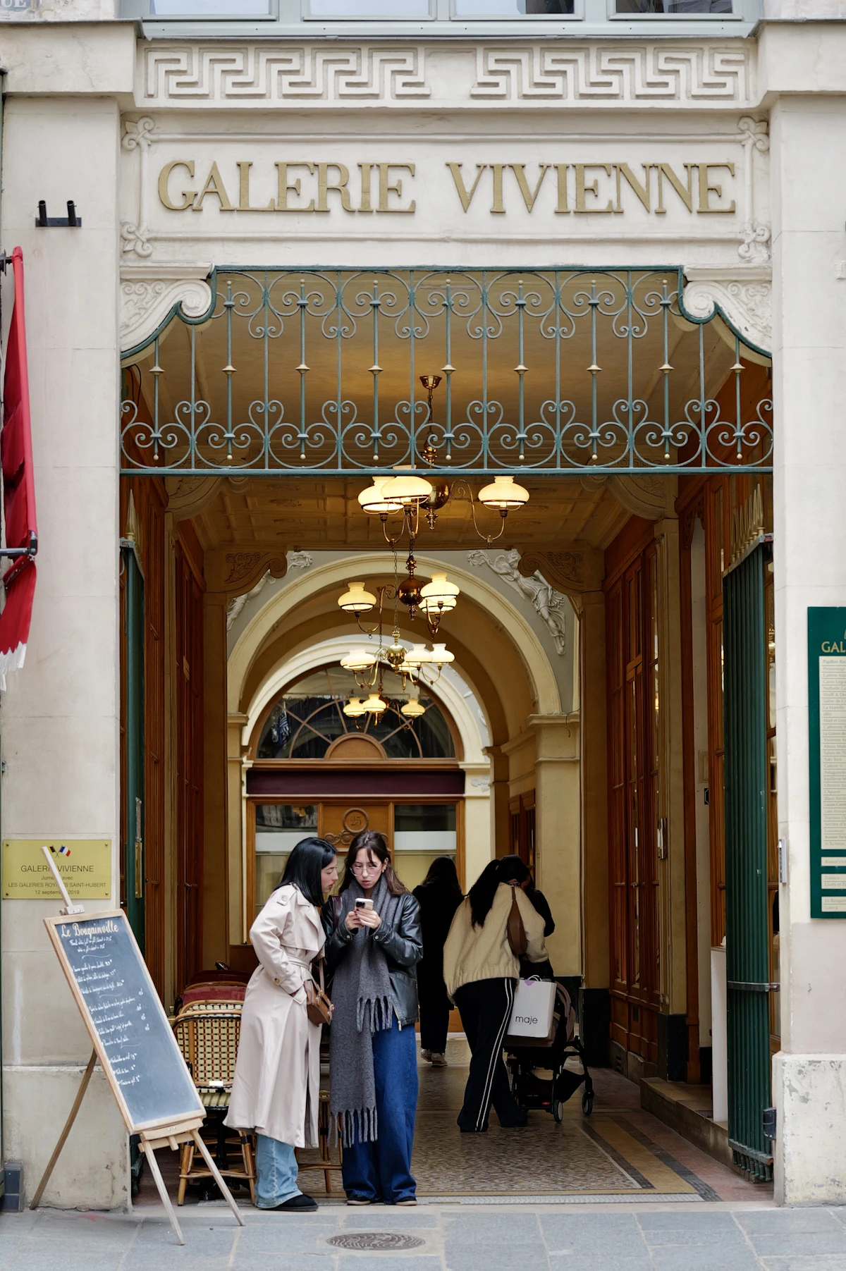 L'entrée dorée de la galerie Vivienne, deux passantes en conversation