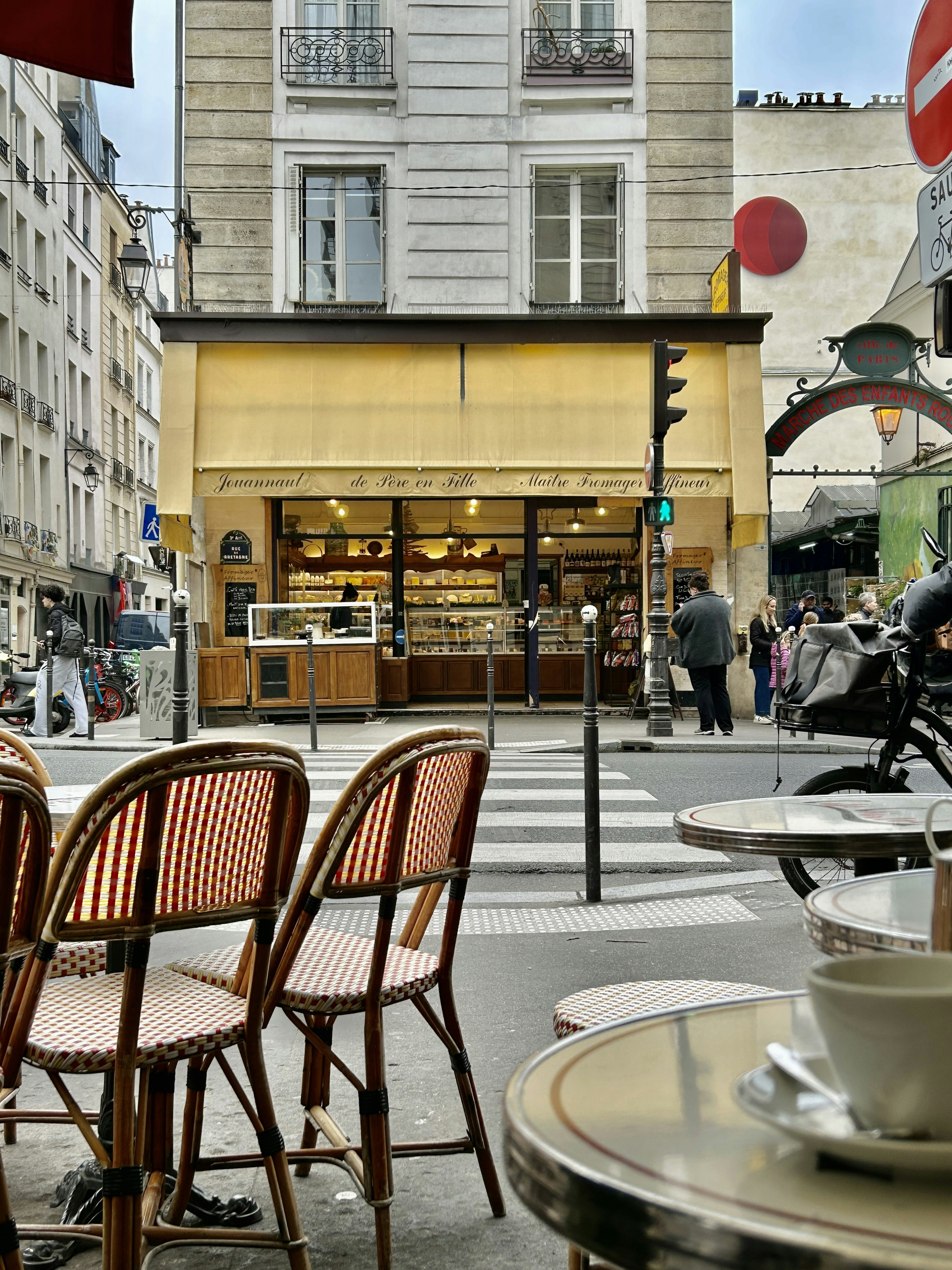 Asientos en una cafetería al aire libre frente a una panadería parisina