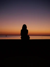 Silhouette of person watching sunset over the ocean