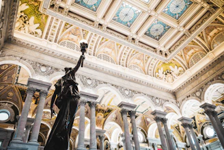 Statue holding torch in ornate classical building interior