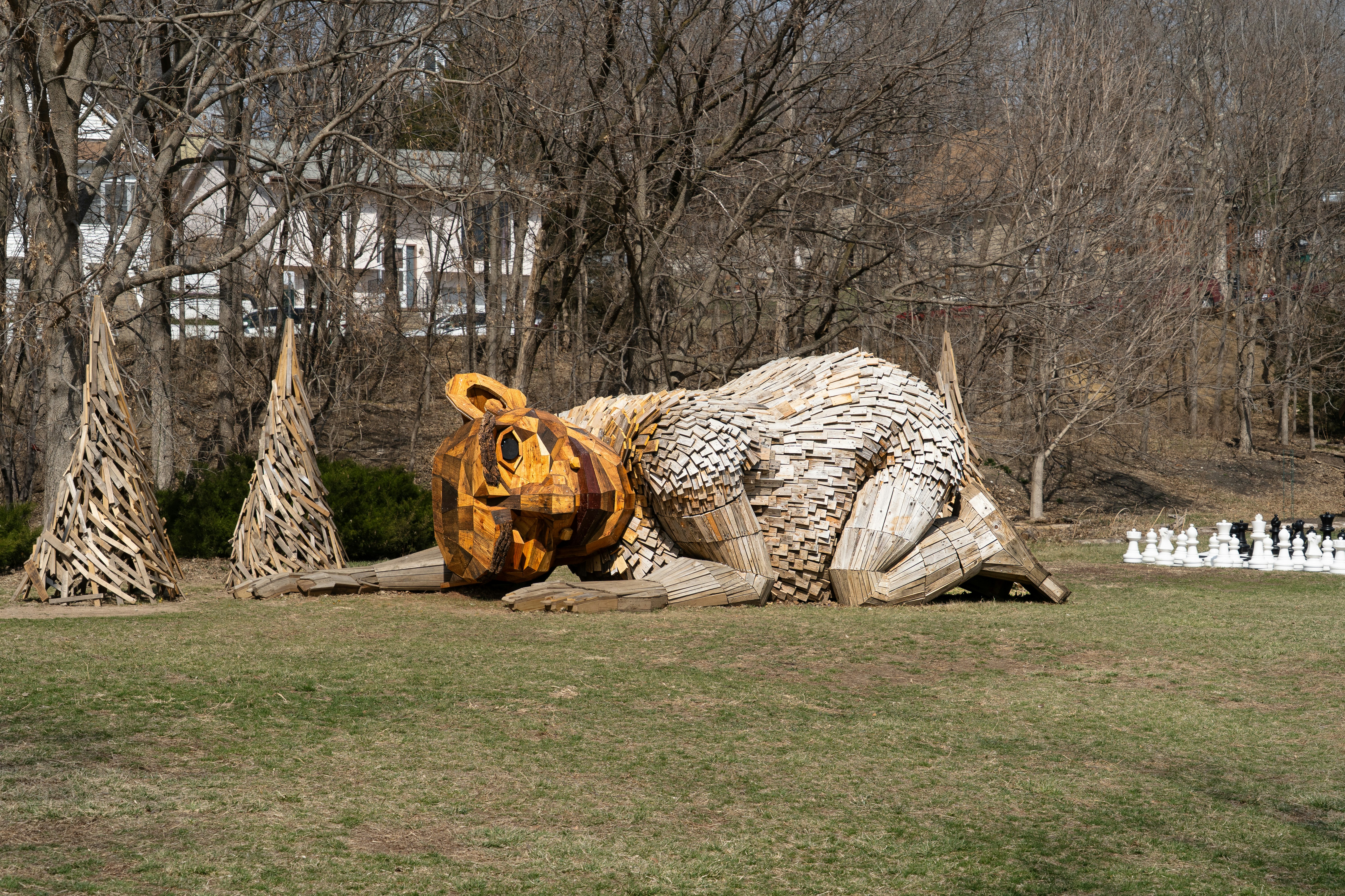 Große Tierskulptur, die auf einem grasbewachsenen Feld ruht