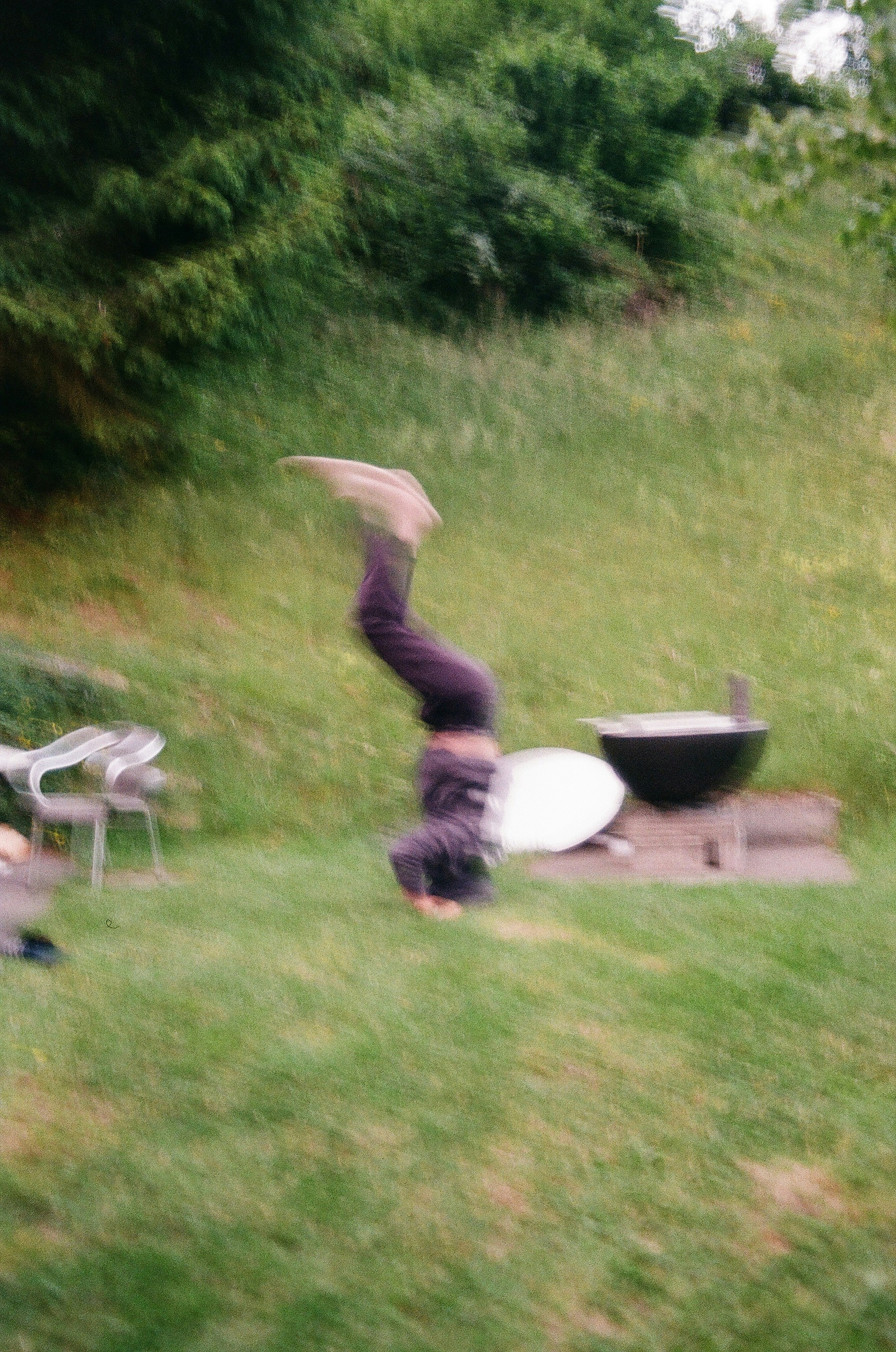Person doing a handstand in a grassy backyard