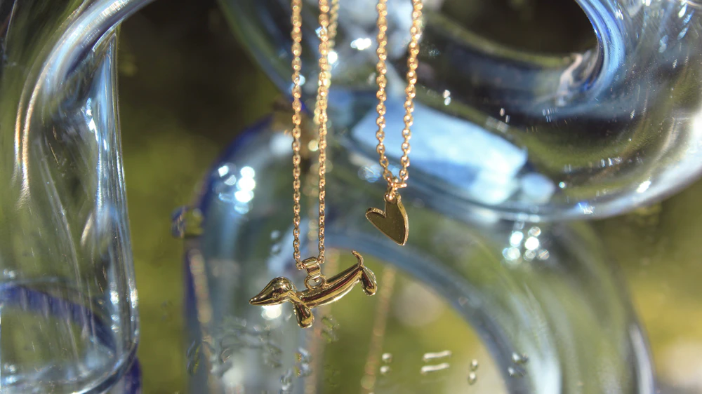 Gold necklaces displayed against a glass surface