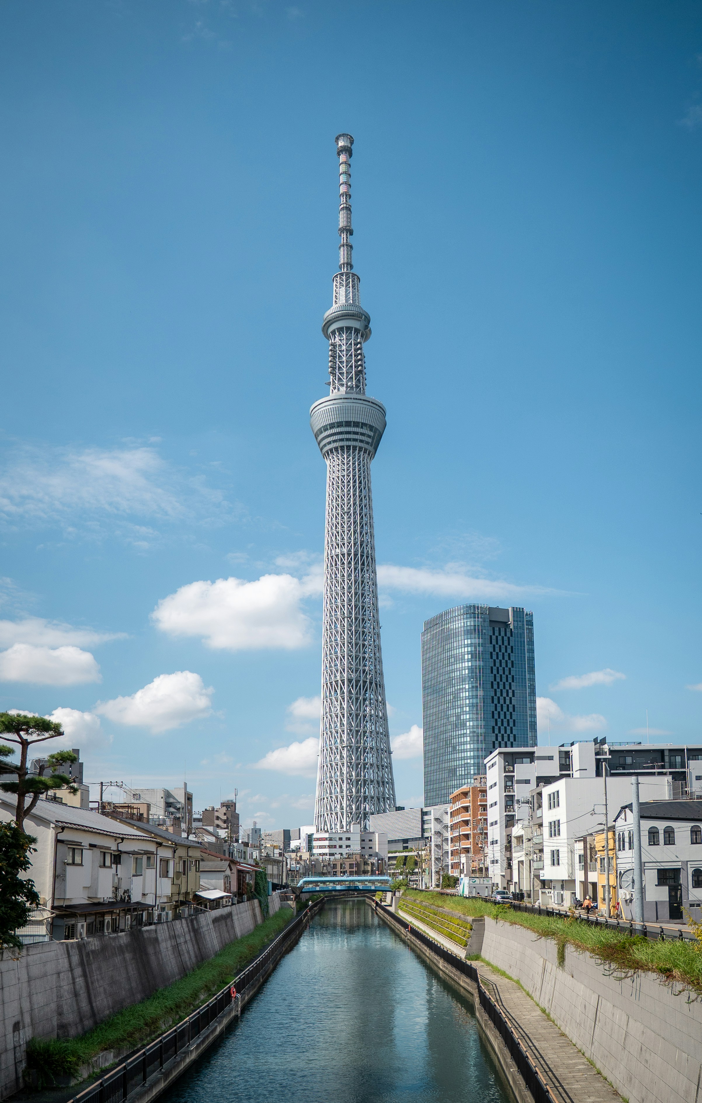 Tall tower overlooking a canal in a city.