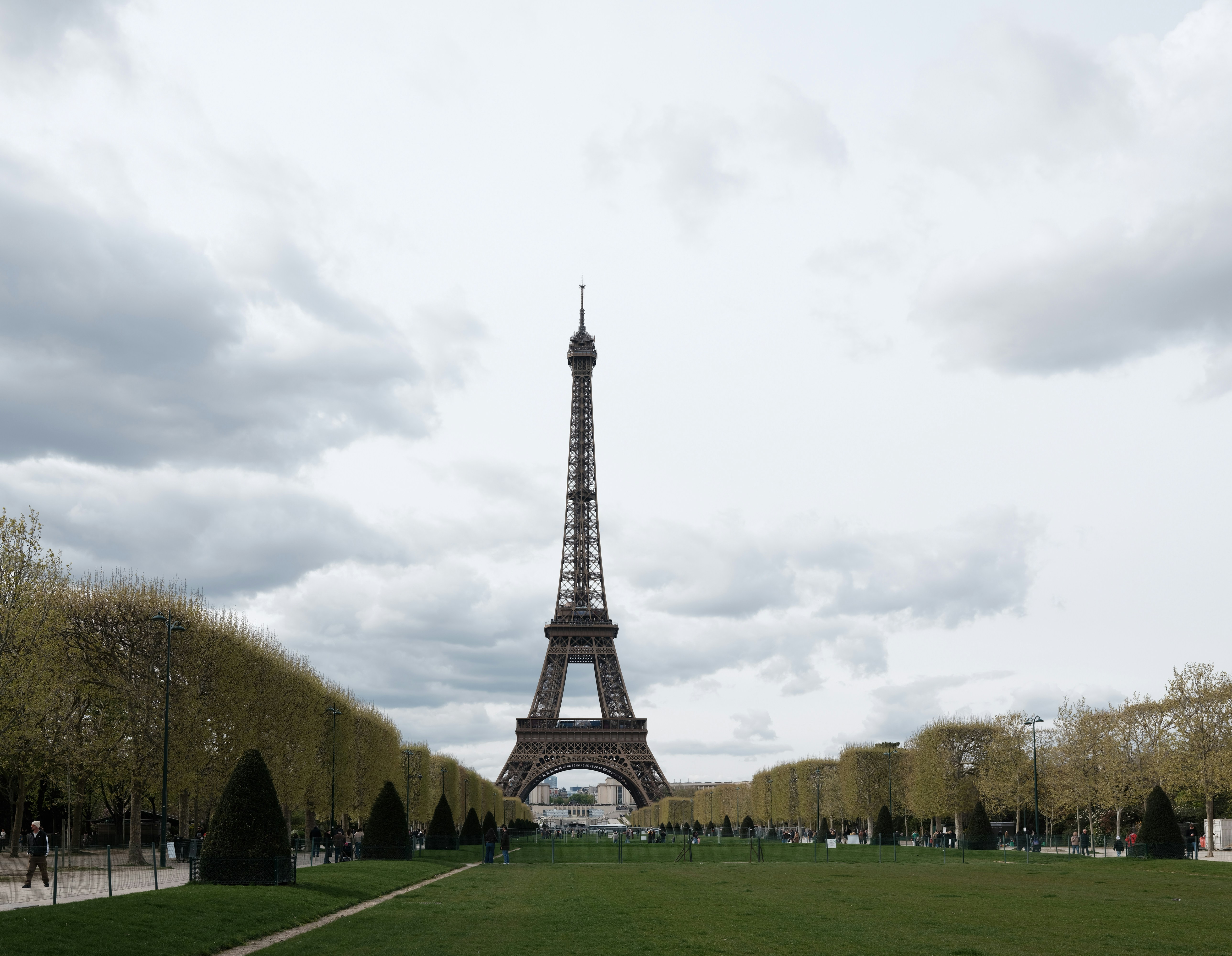 The eiffel tower stands tall against a cloudy sky.