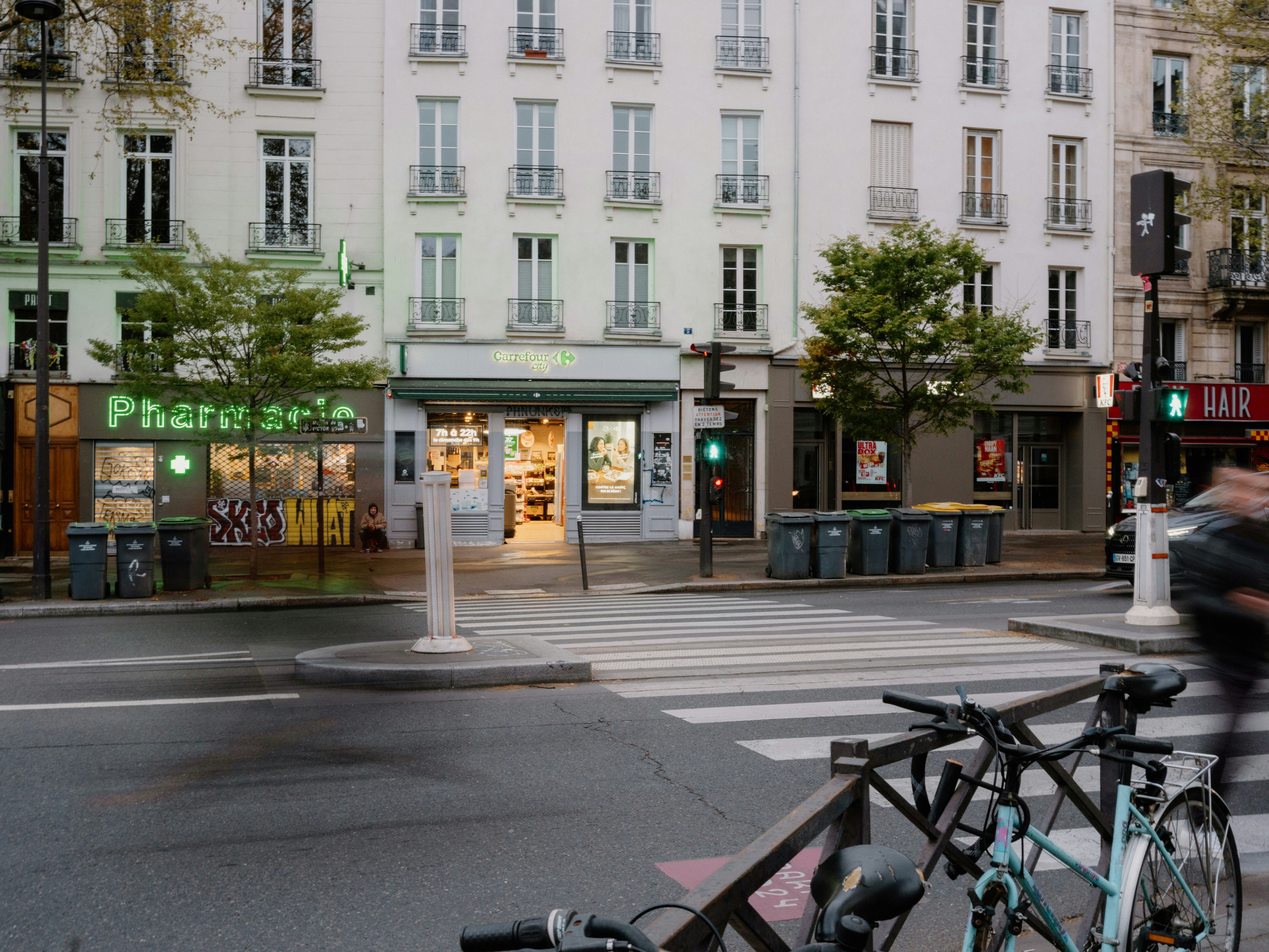 Cena de rua com farmácia e prédios em Paris