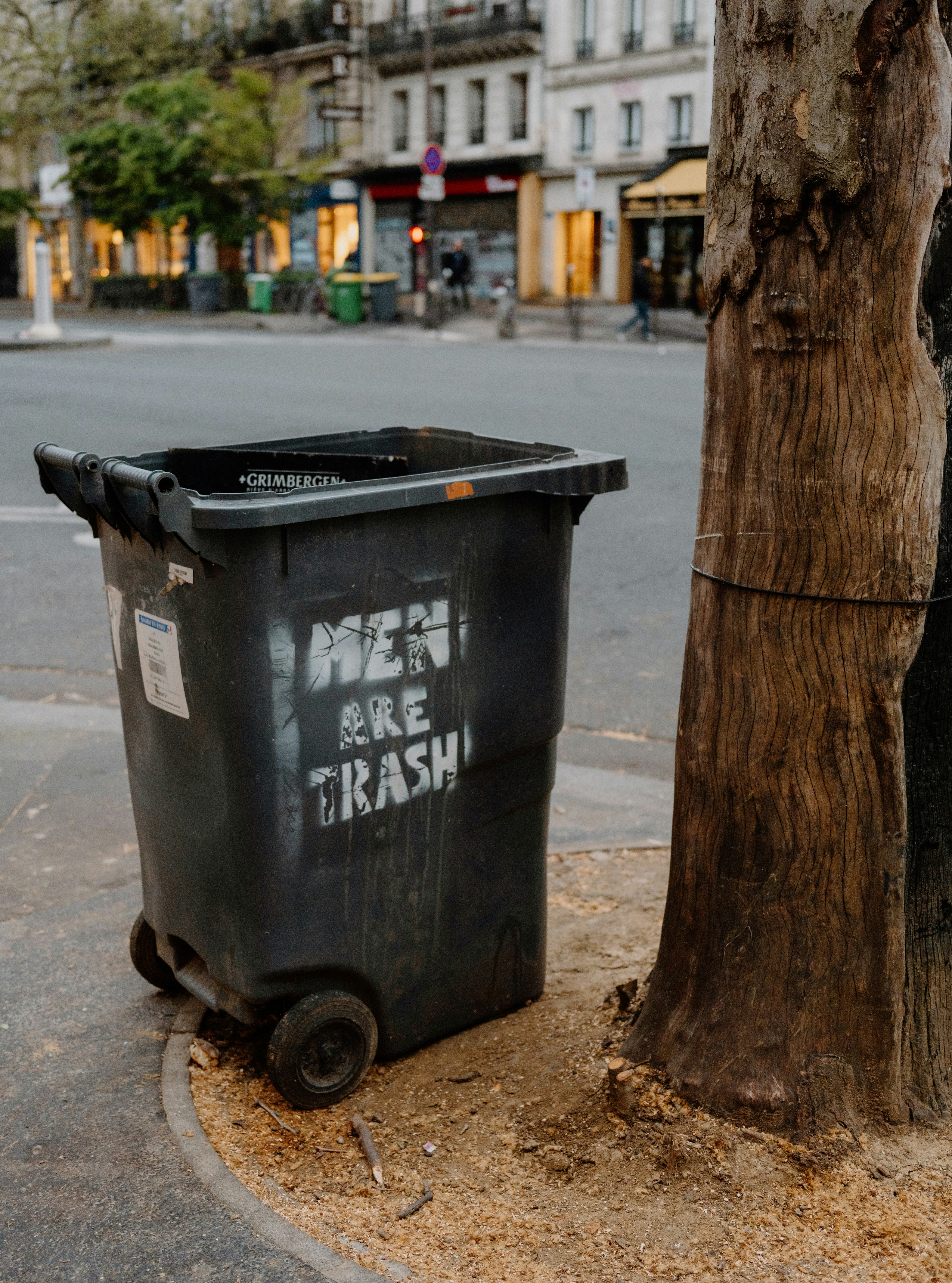 A trash can with graffiti that says "men are trash".
