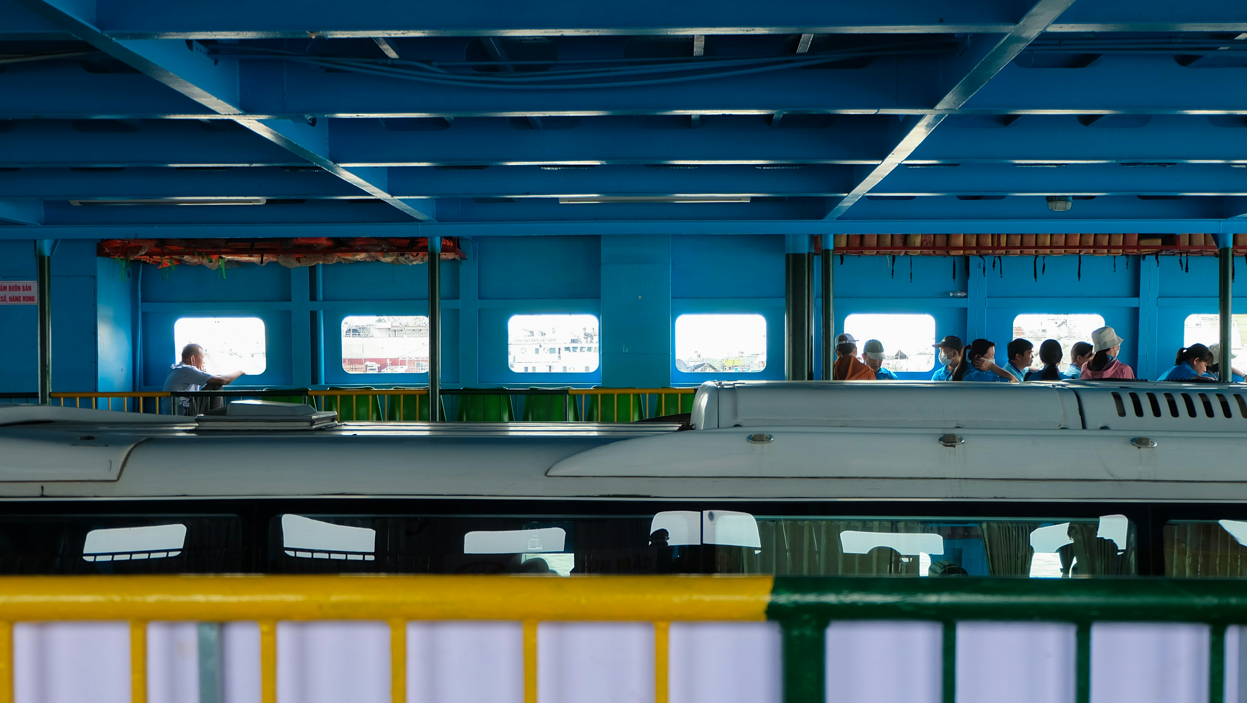 People inside a train with blue interior and white interior.