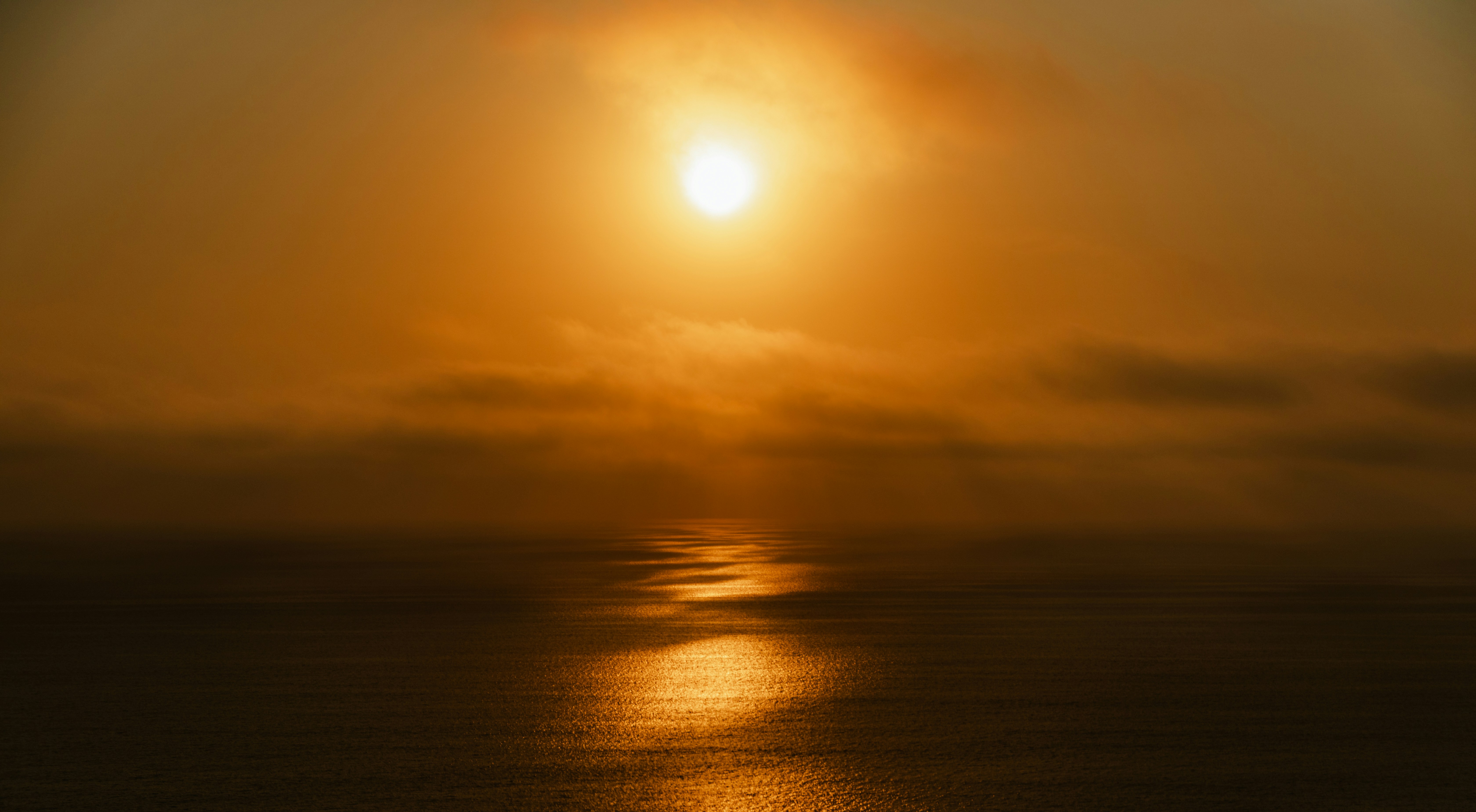 穏やかな海の上に沈む黄金の夕日。