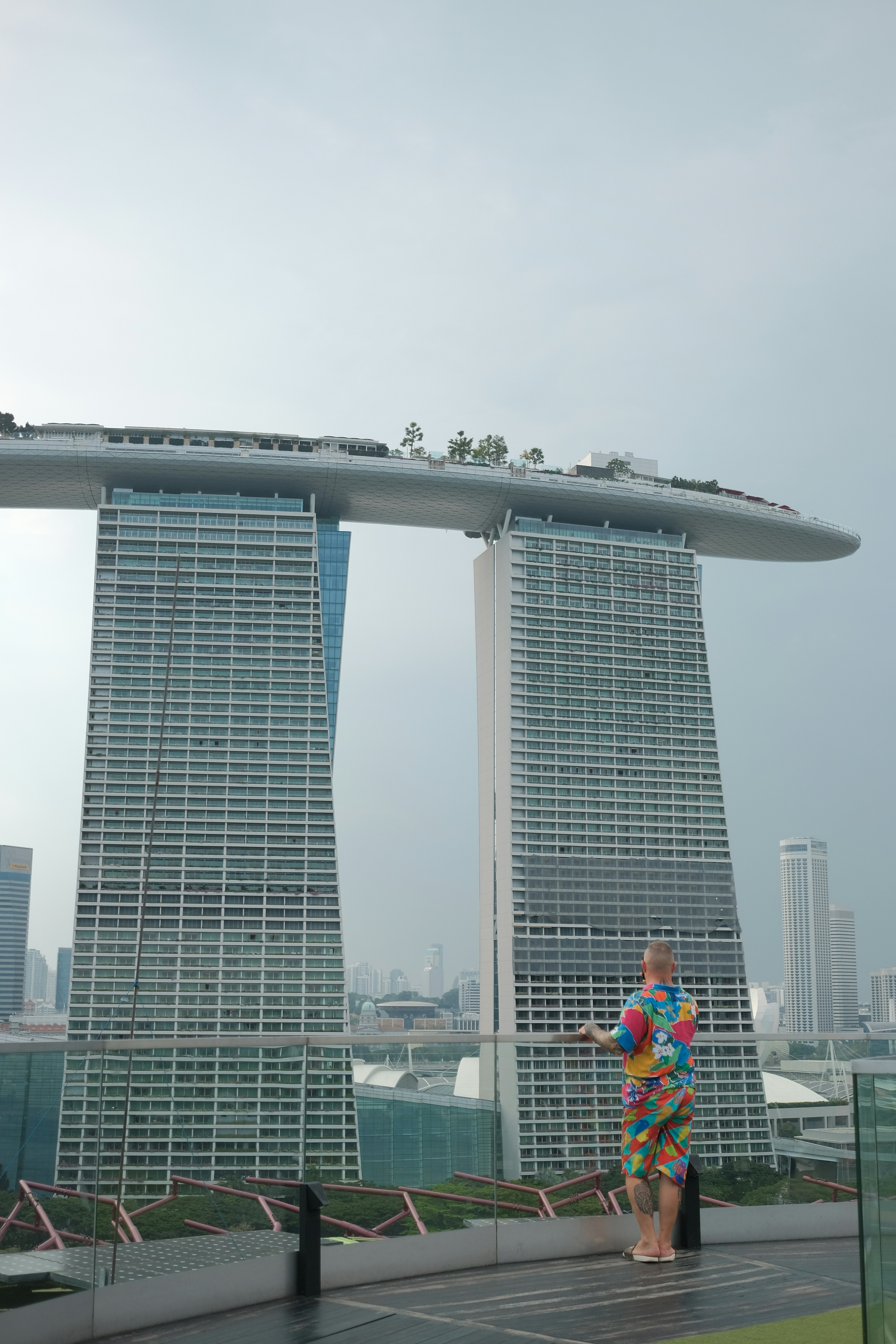 Man in colorful shirt overlooks futuristic skyscrapers