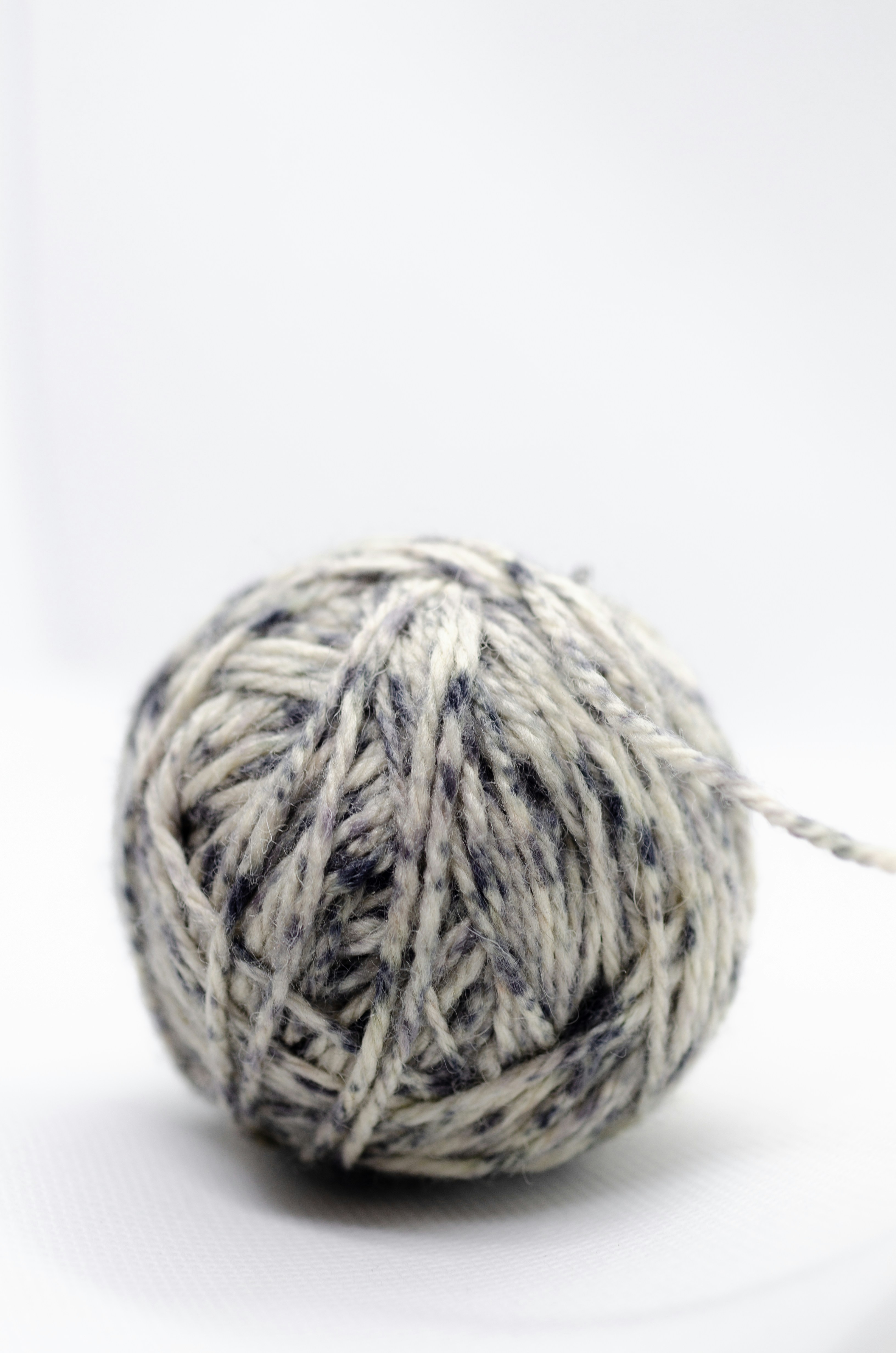 Ball of speckled yarn on a white background