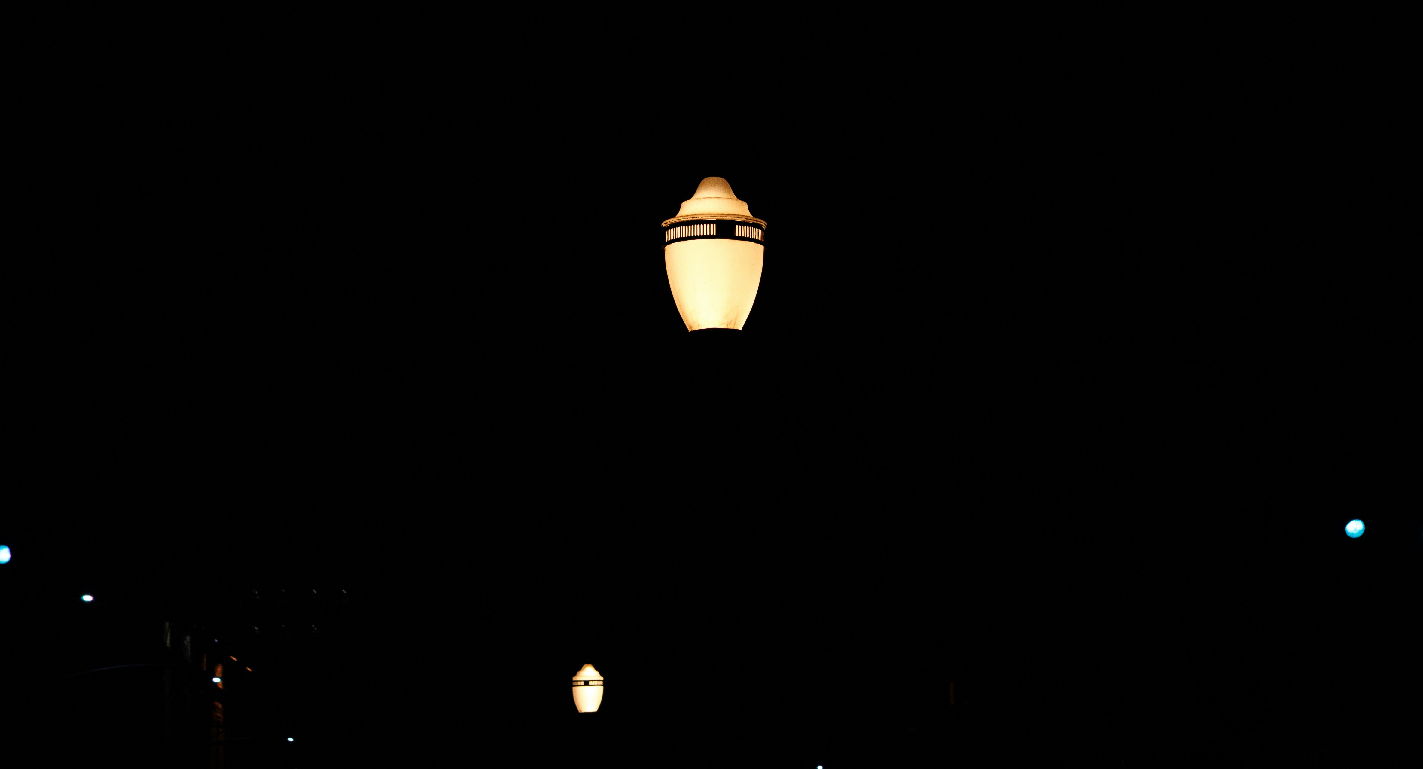Street lamps glowing at night in the dark.