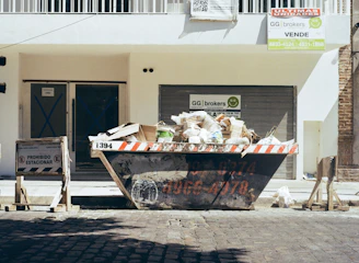 A dumpster filled with trash on a street.