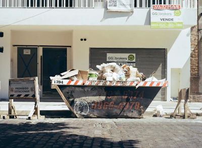 A dumpster filled with trash on a street.
