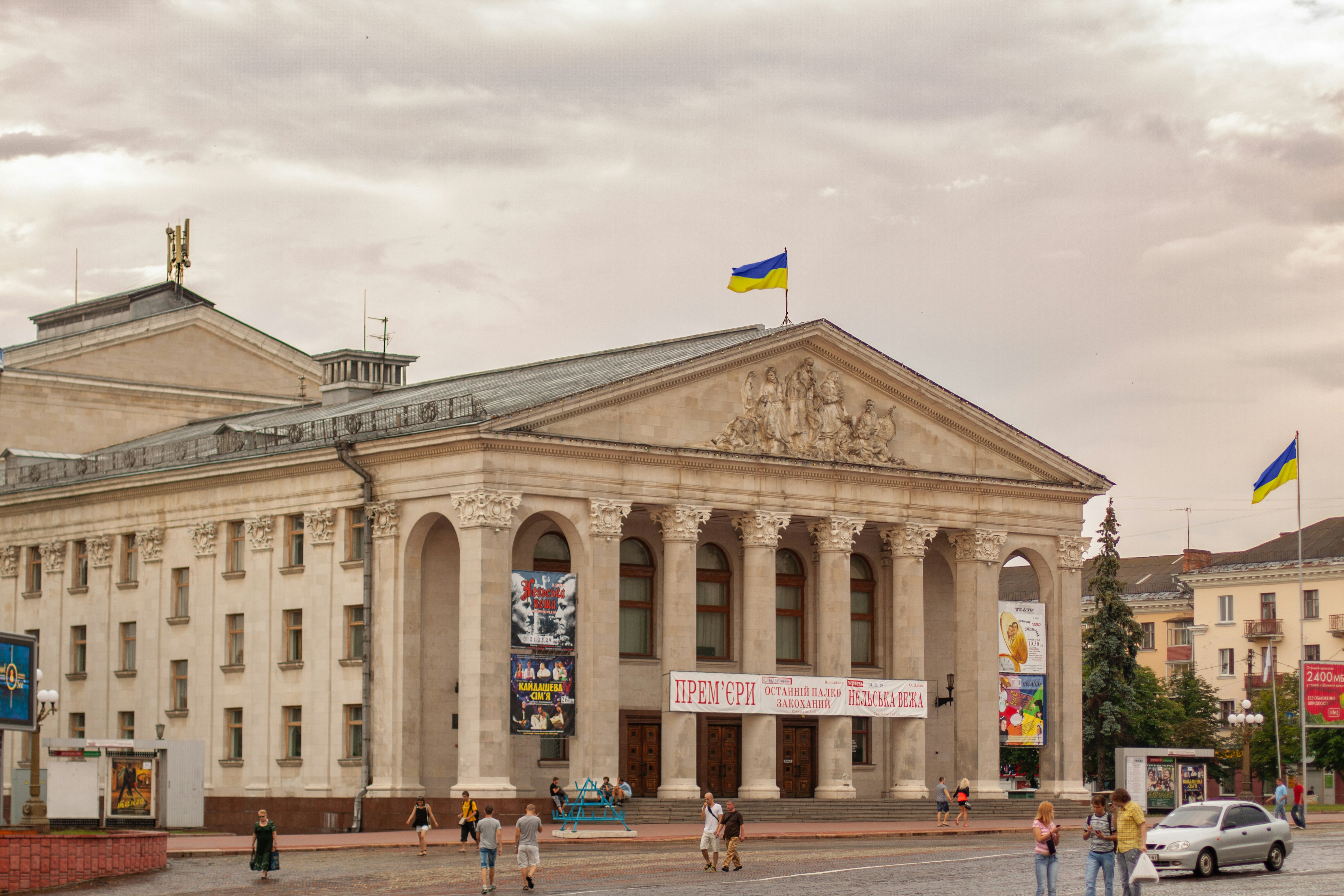 Grand neoclassical building with columns and ukrainian flags.