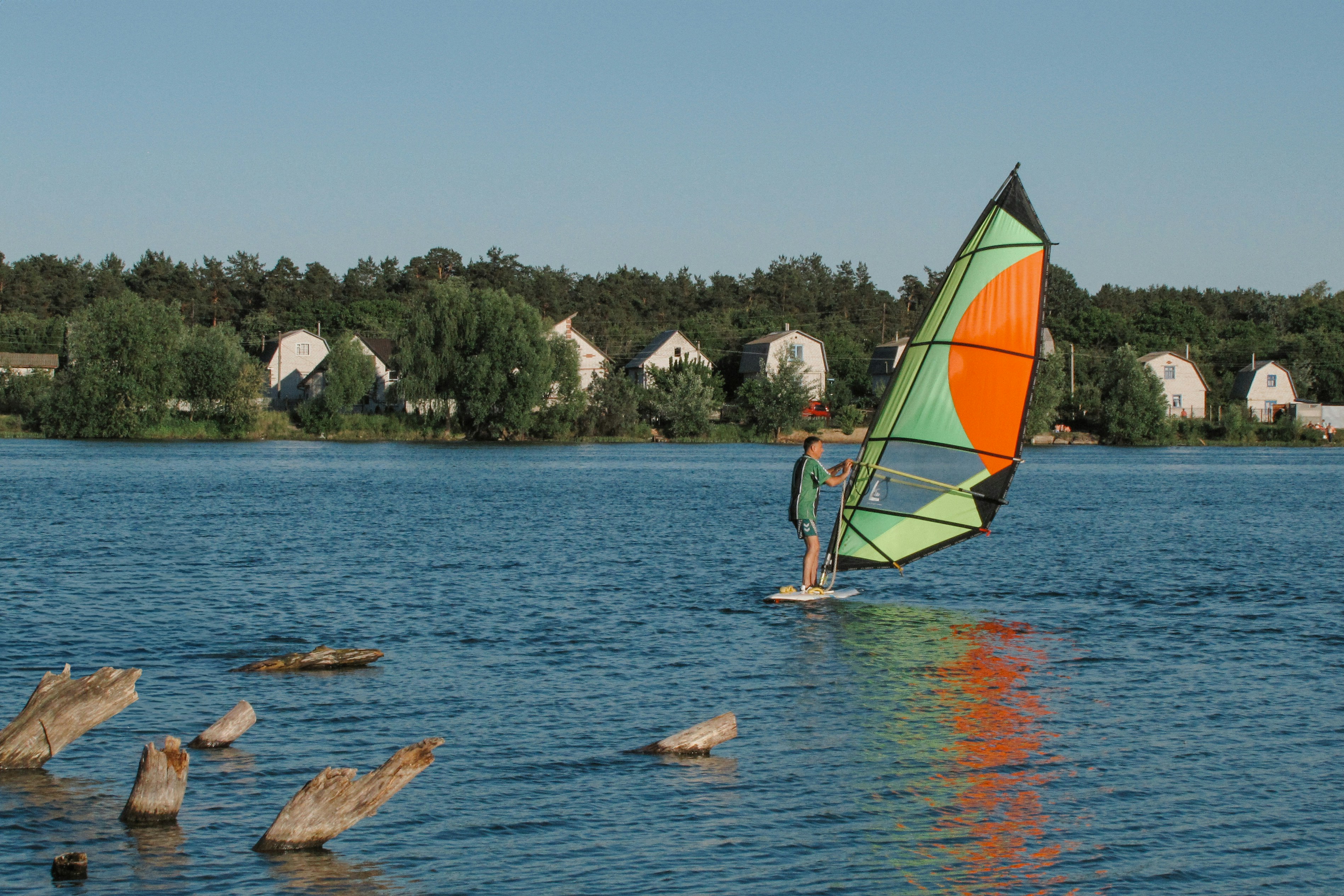 Windsurfer on a lake with houses in the background