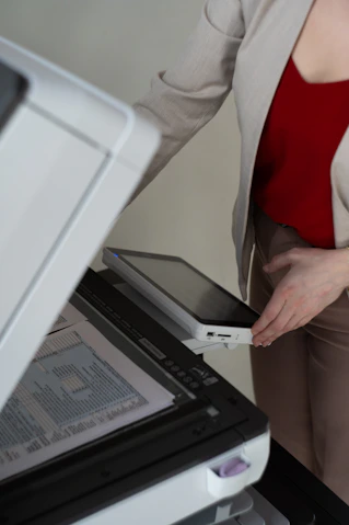 Woman placing tablet into scanner document feeder
