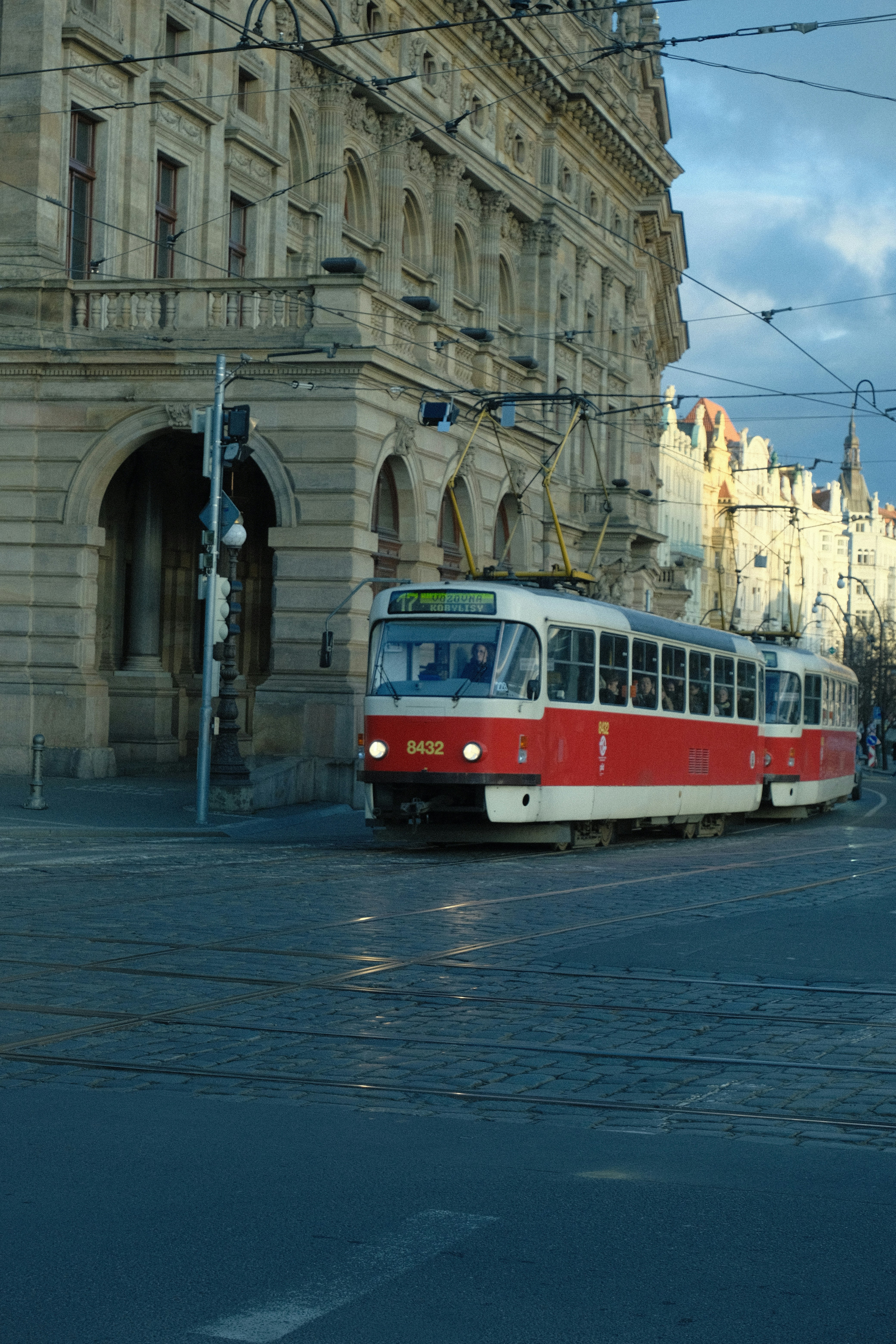 A red and white tram on a city street.