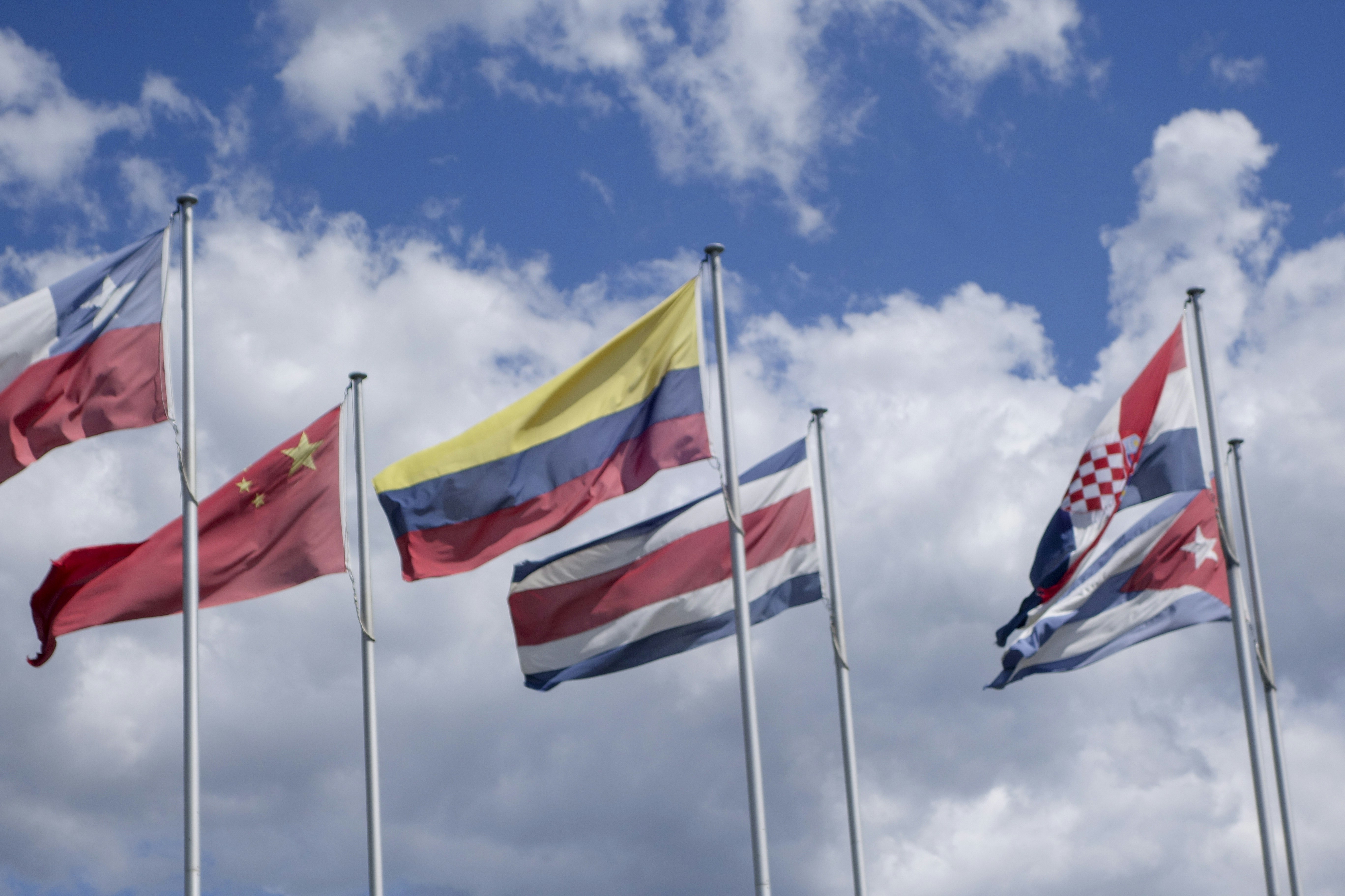 Mehrere Nationalflaggen wehten gegen einen bewölkten Himmel.