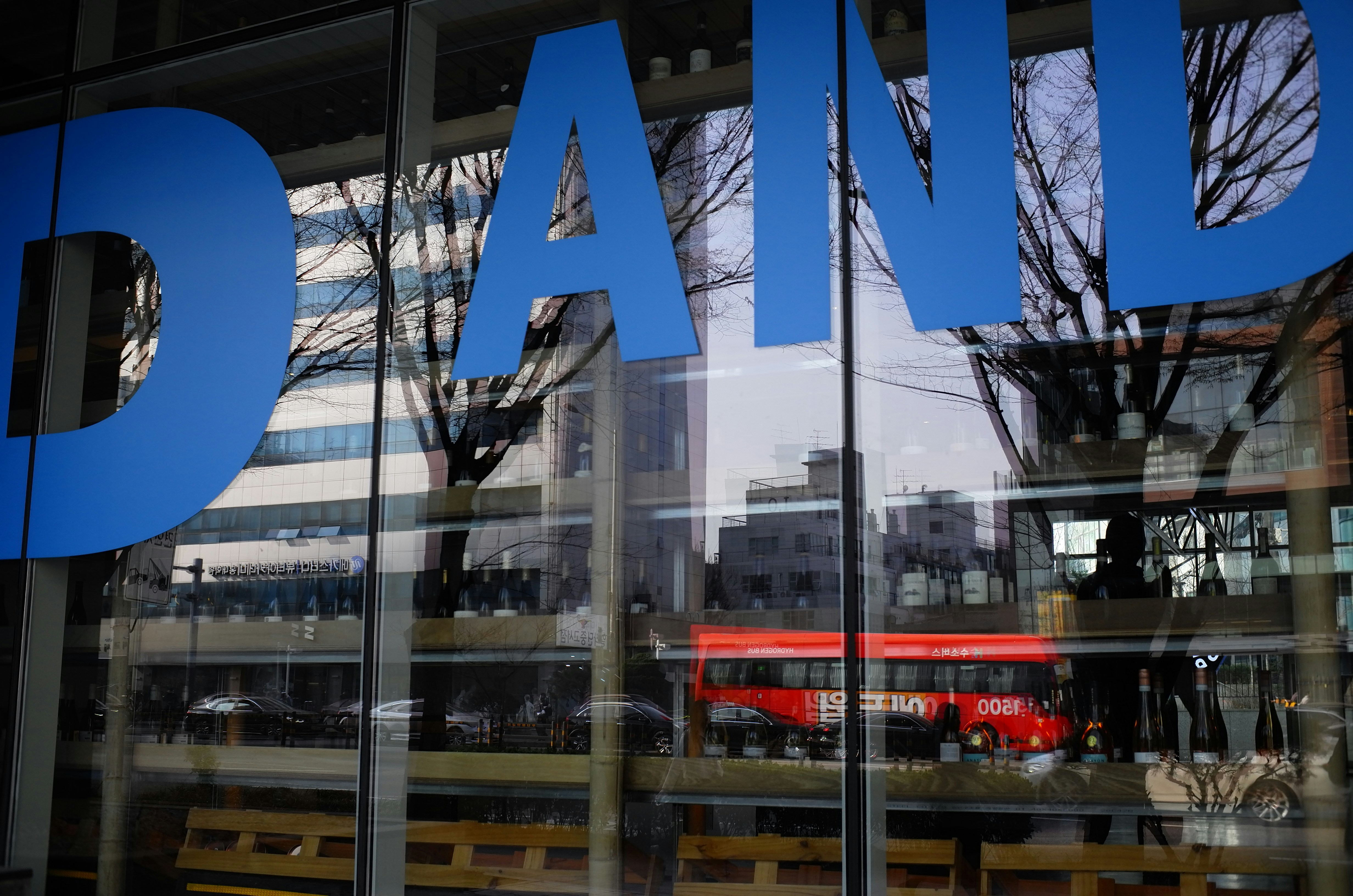 Blue letters on glass with city reflection