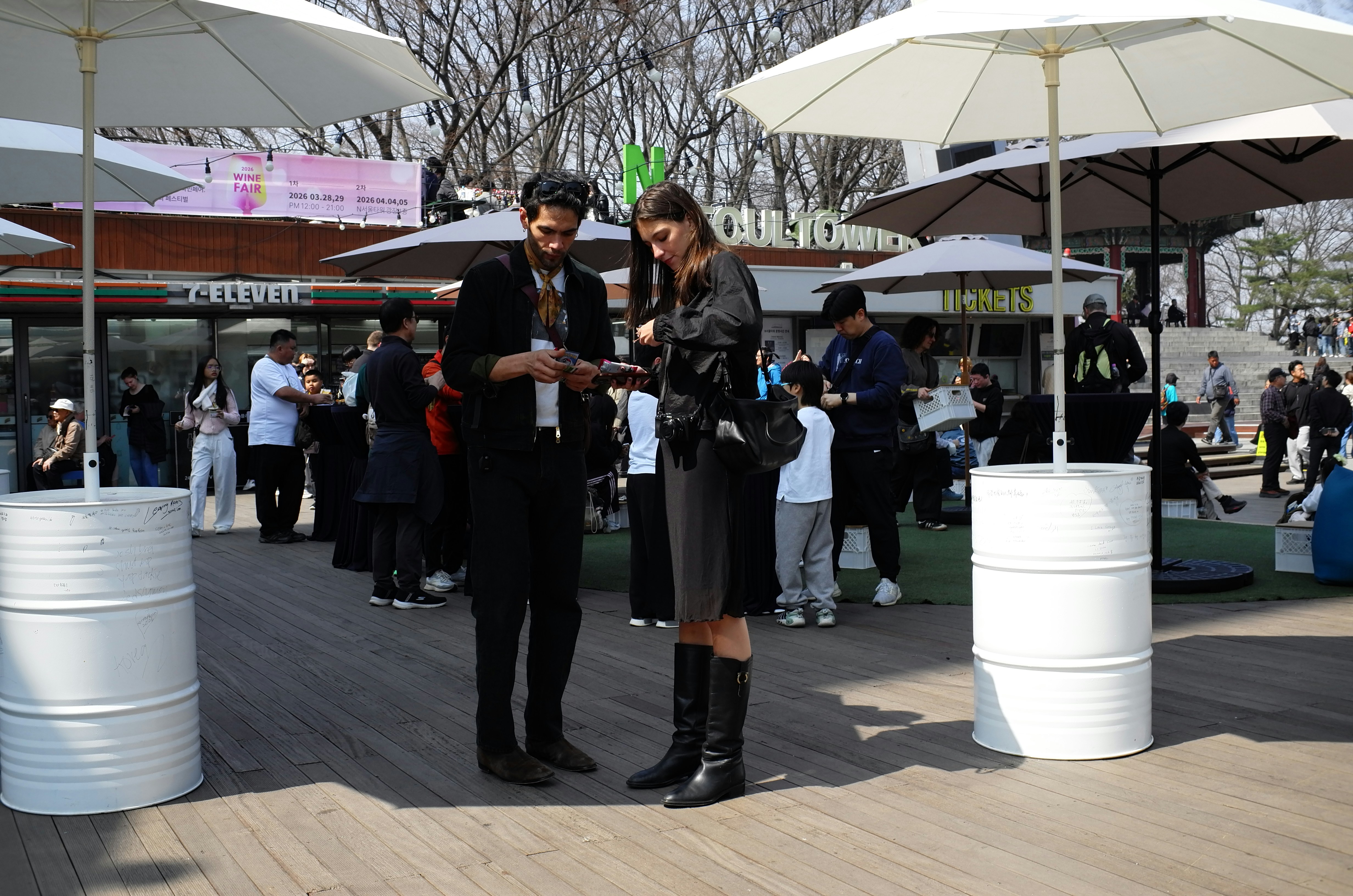 A couple looks at a phone outdoors