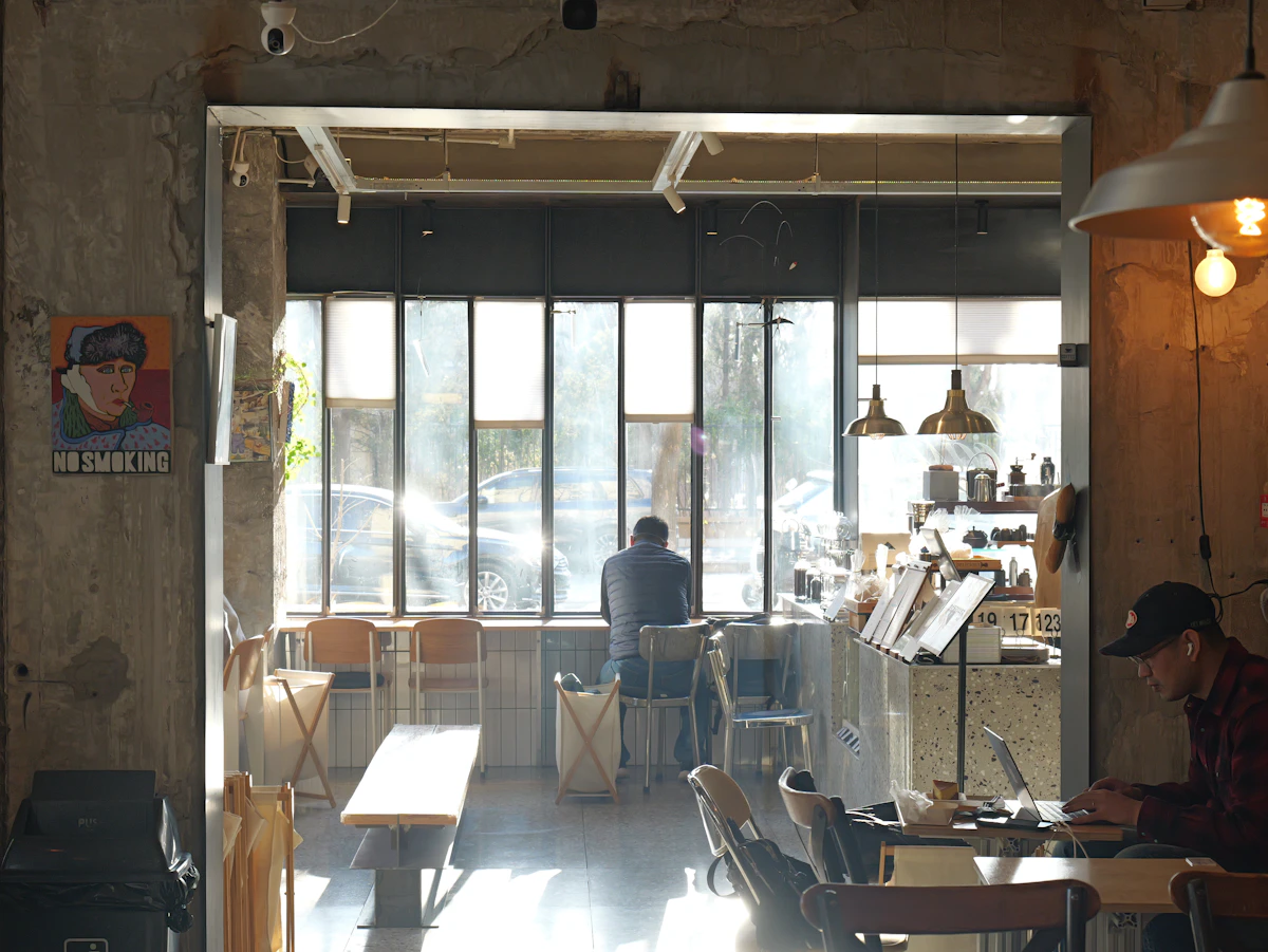 Professionnel travaillant sur un ordinateur dans un café lumineux