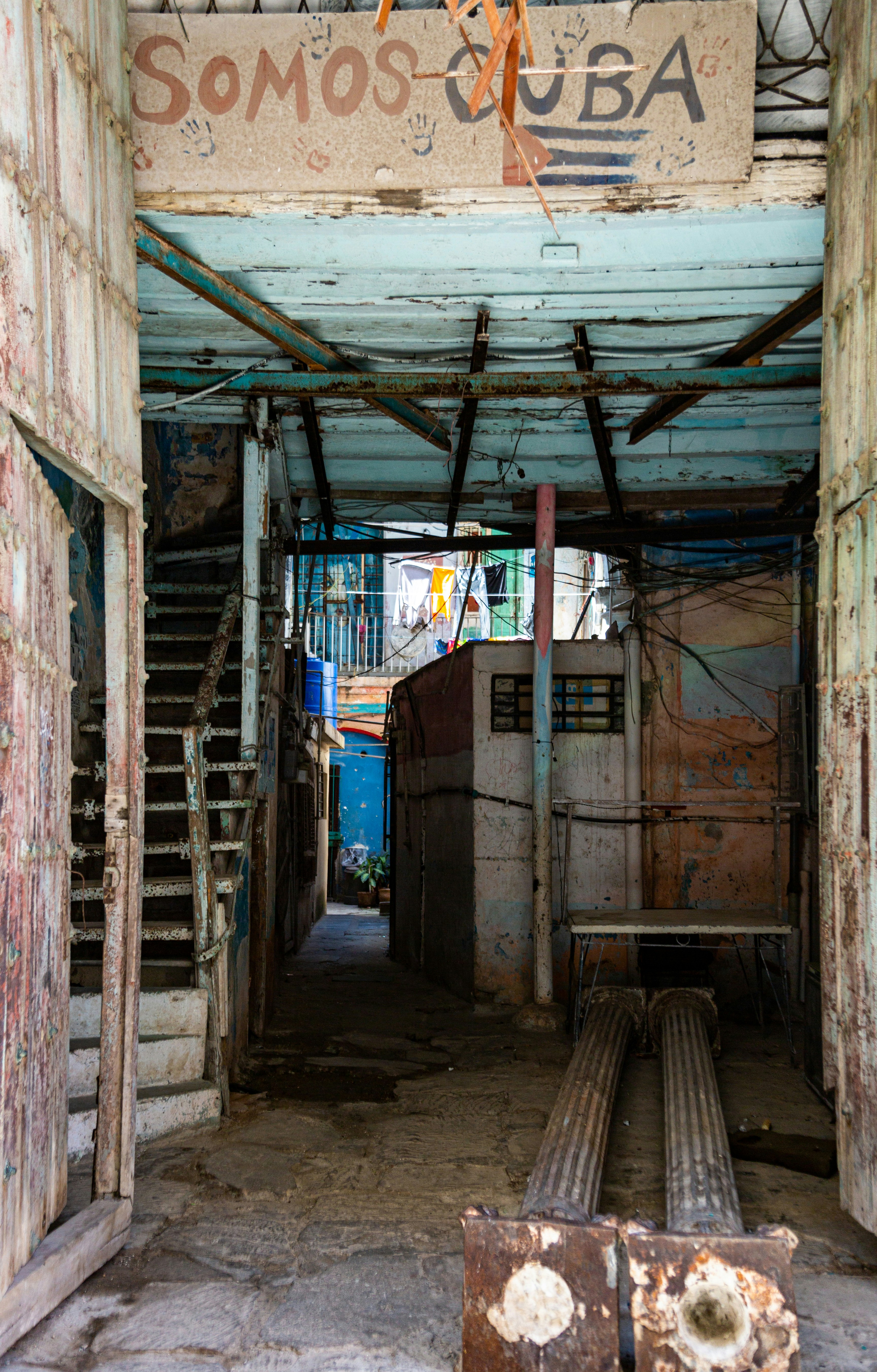 Une ruelle usée avec un panneau « somos cuba » au-dessus
