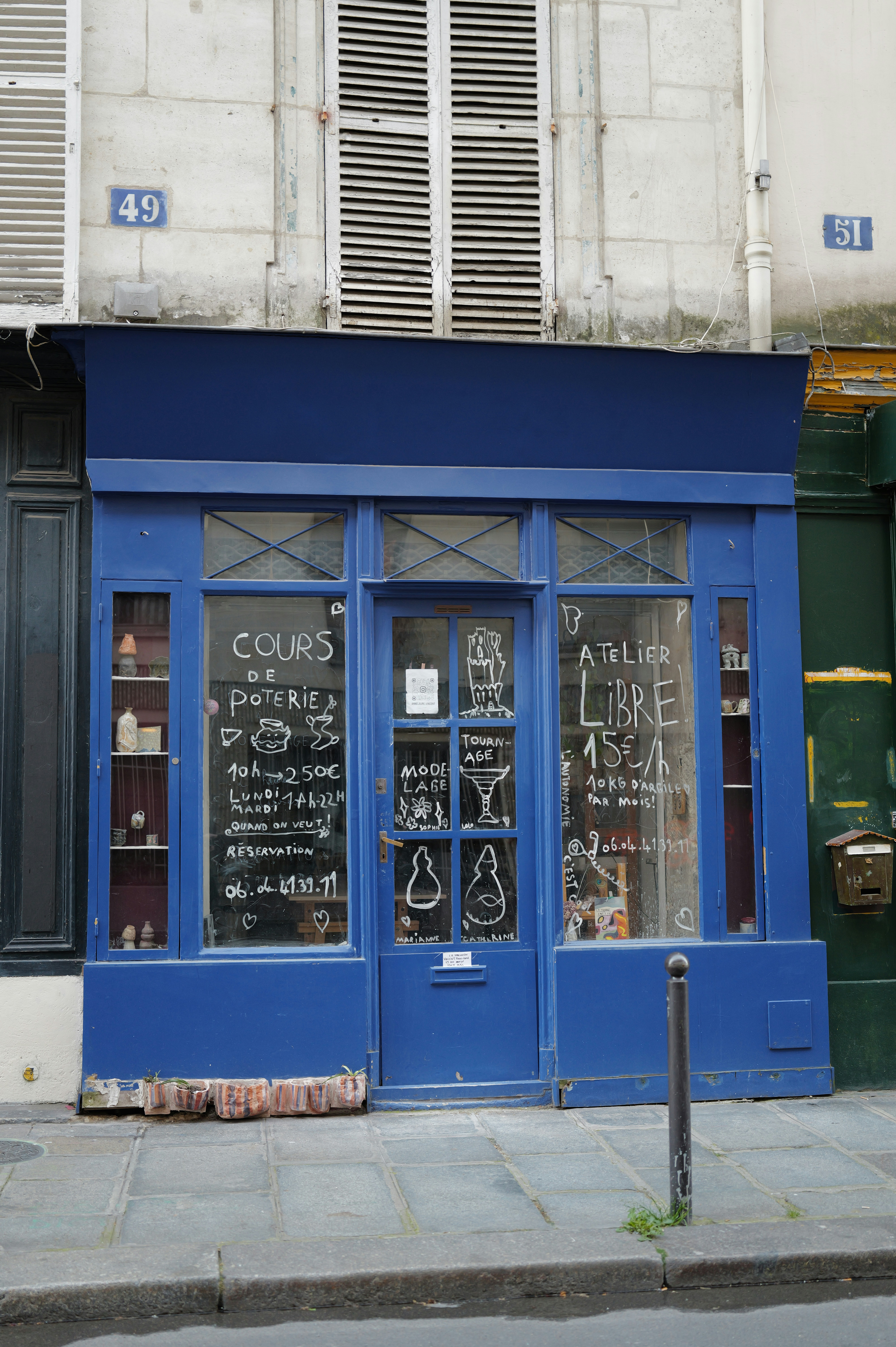 Vitrine bleue avec des présentoirs d’art à la craie et de poteries