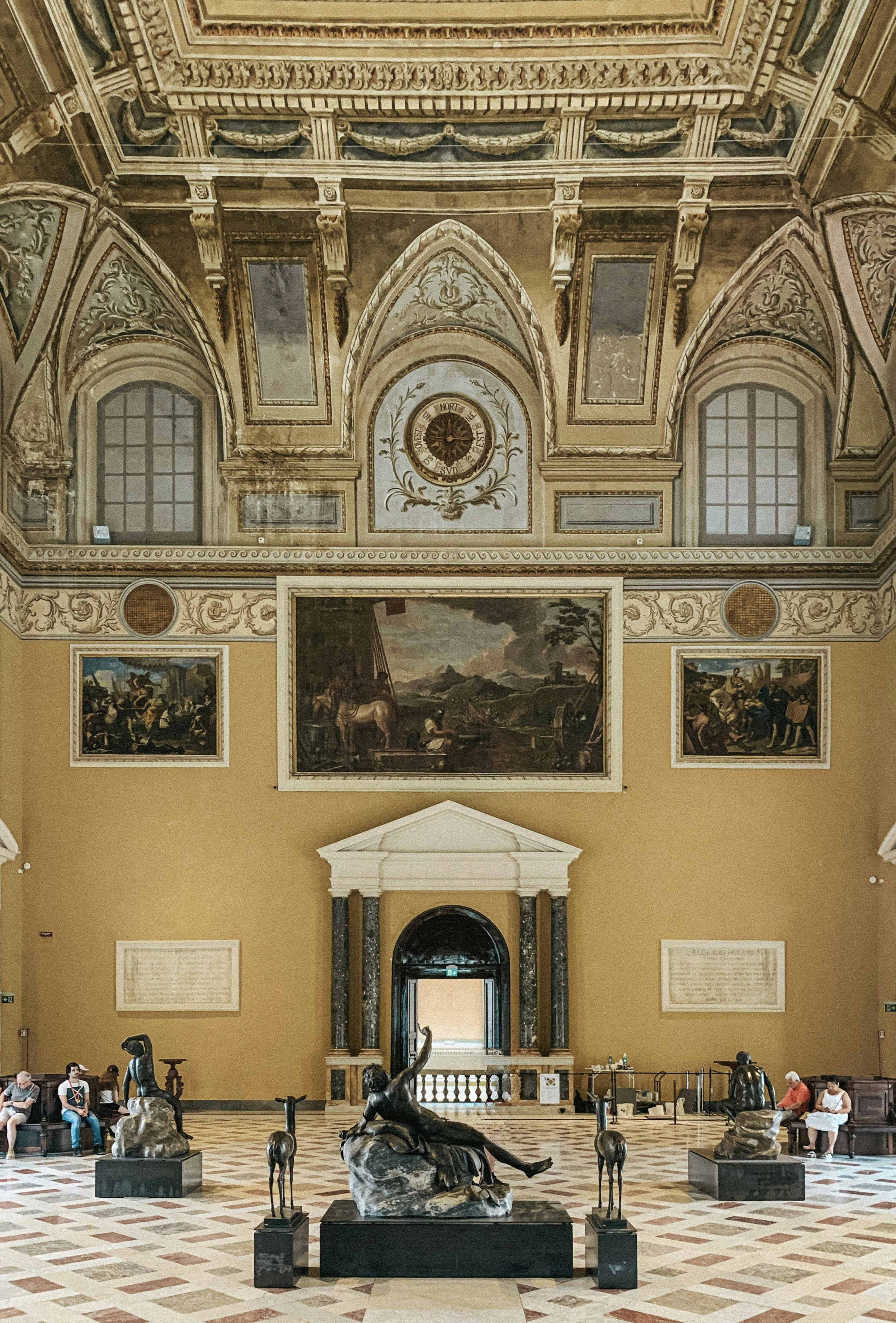 Salón museístico ornamentado con esculturas y pinturas