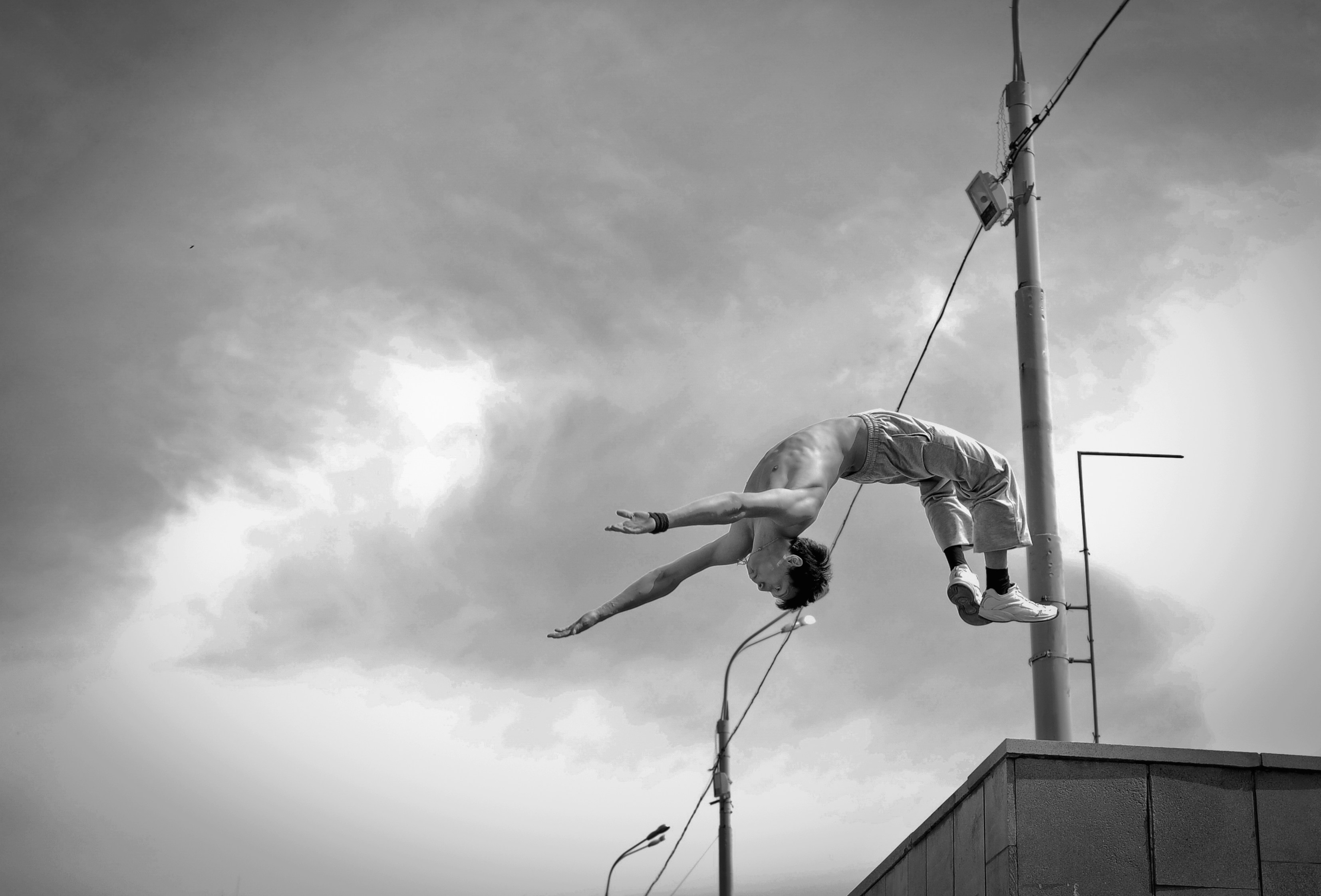 Man performs a backflip on a rooftop