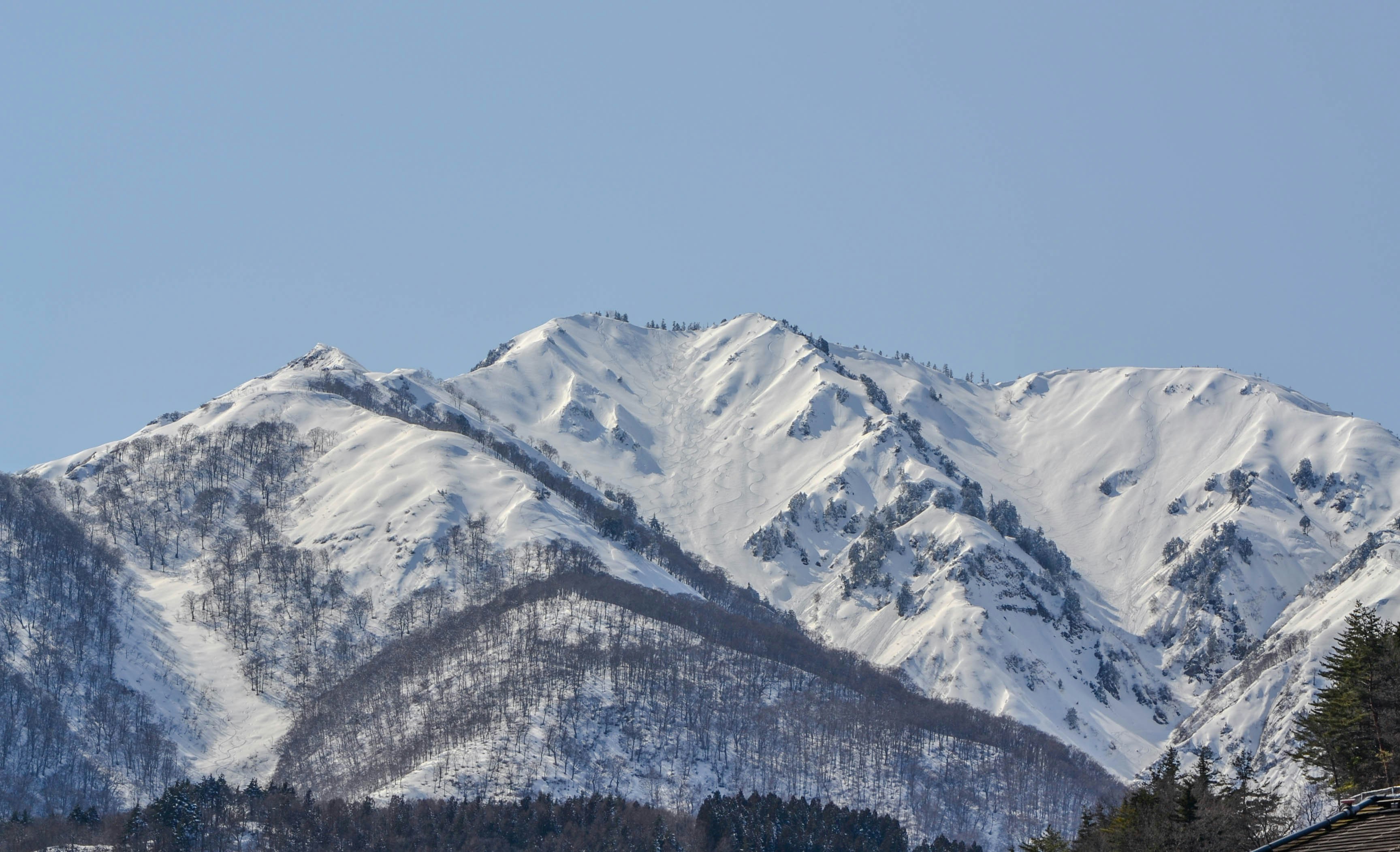 Snow-covered mountain range under a clear blue sky