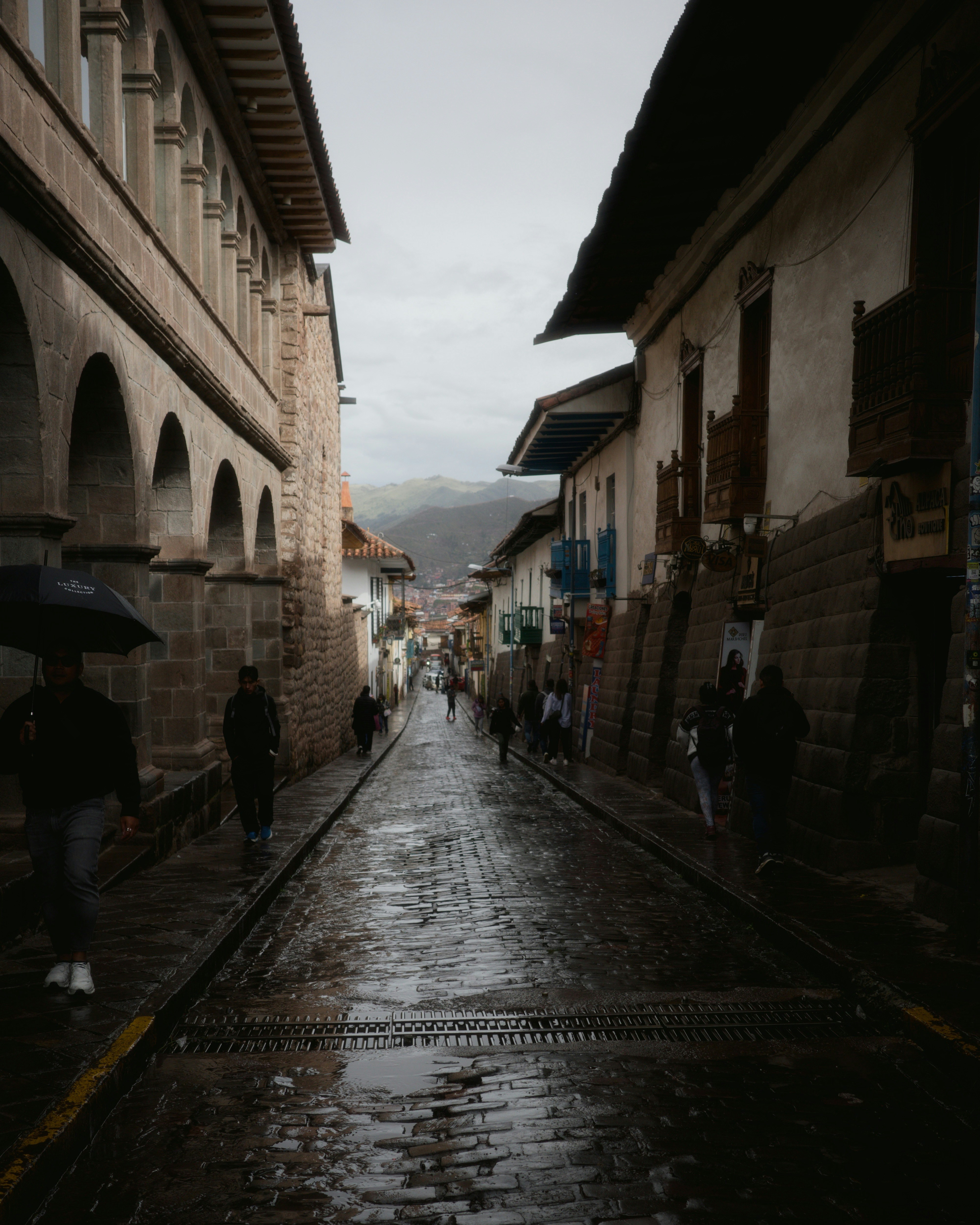 Cobblestone street in a historic town on a rainy day.