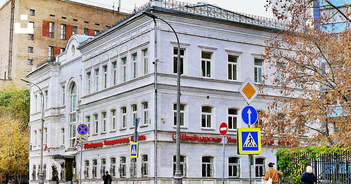 White building with signs and people on street photo – Free City Image ...