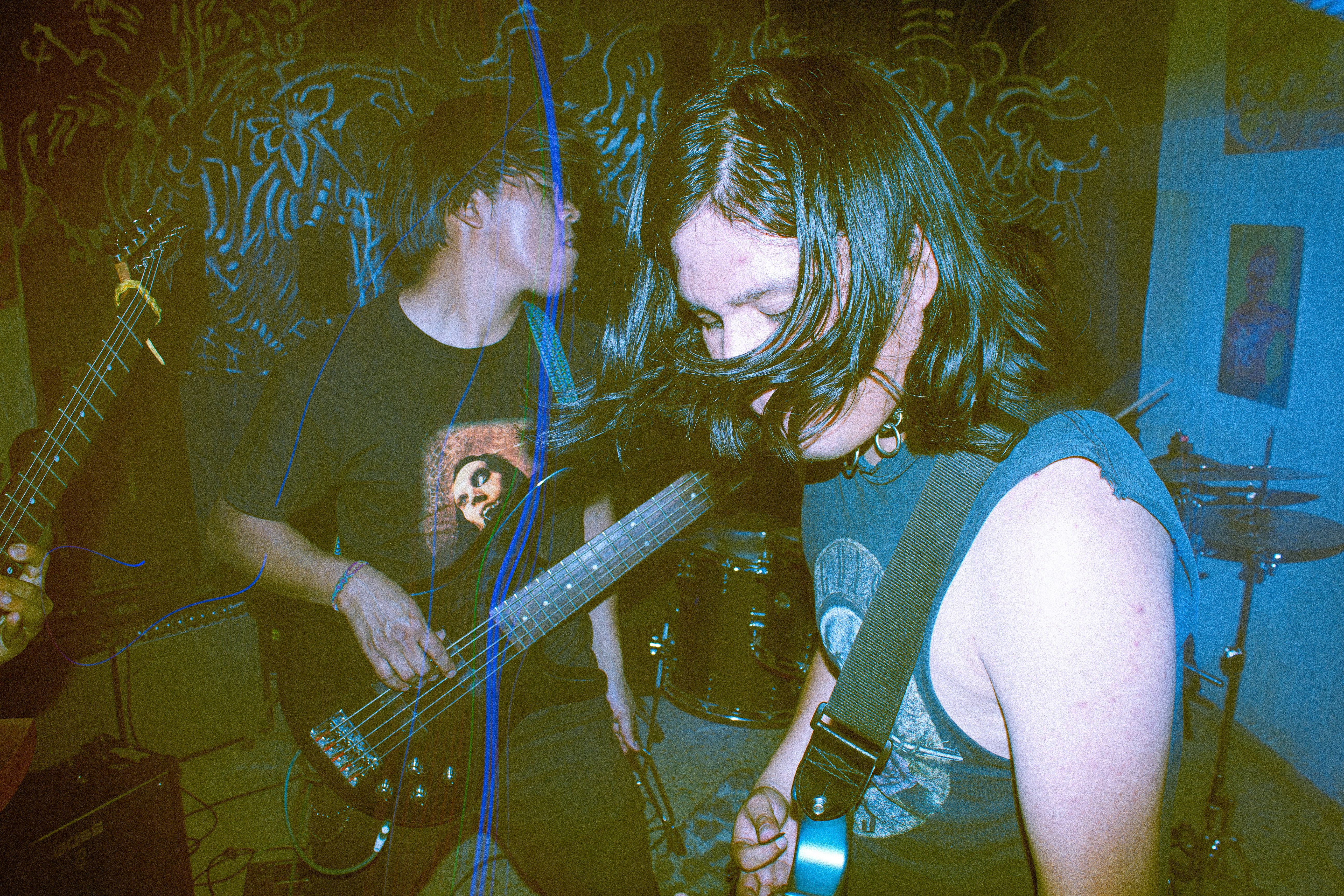 Musicians playing guitars in a dimly lit room.