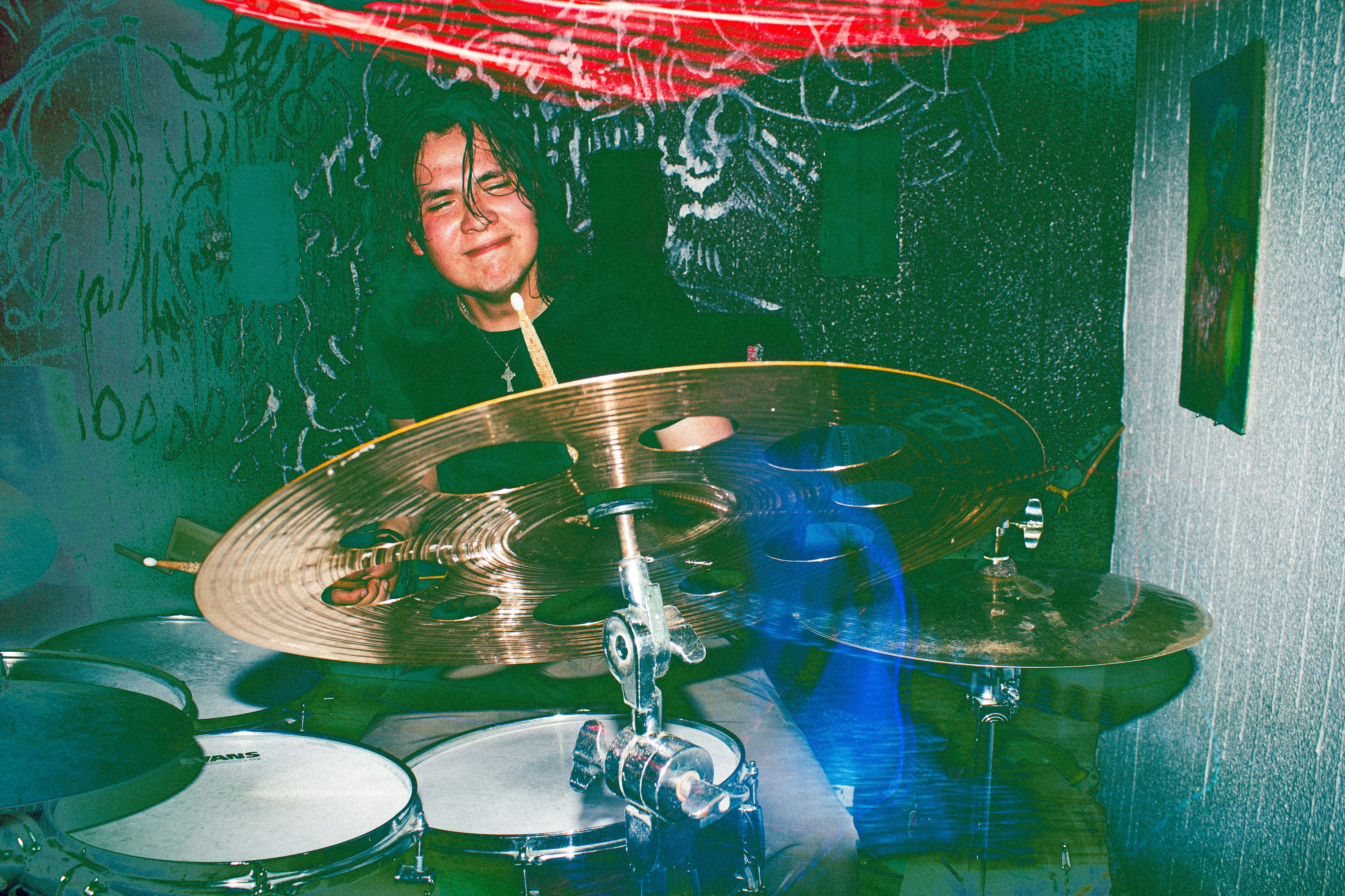 A young man playing drums with sticks