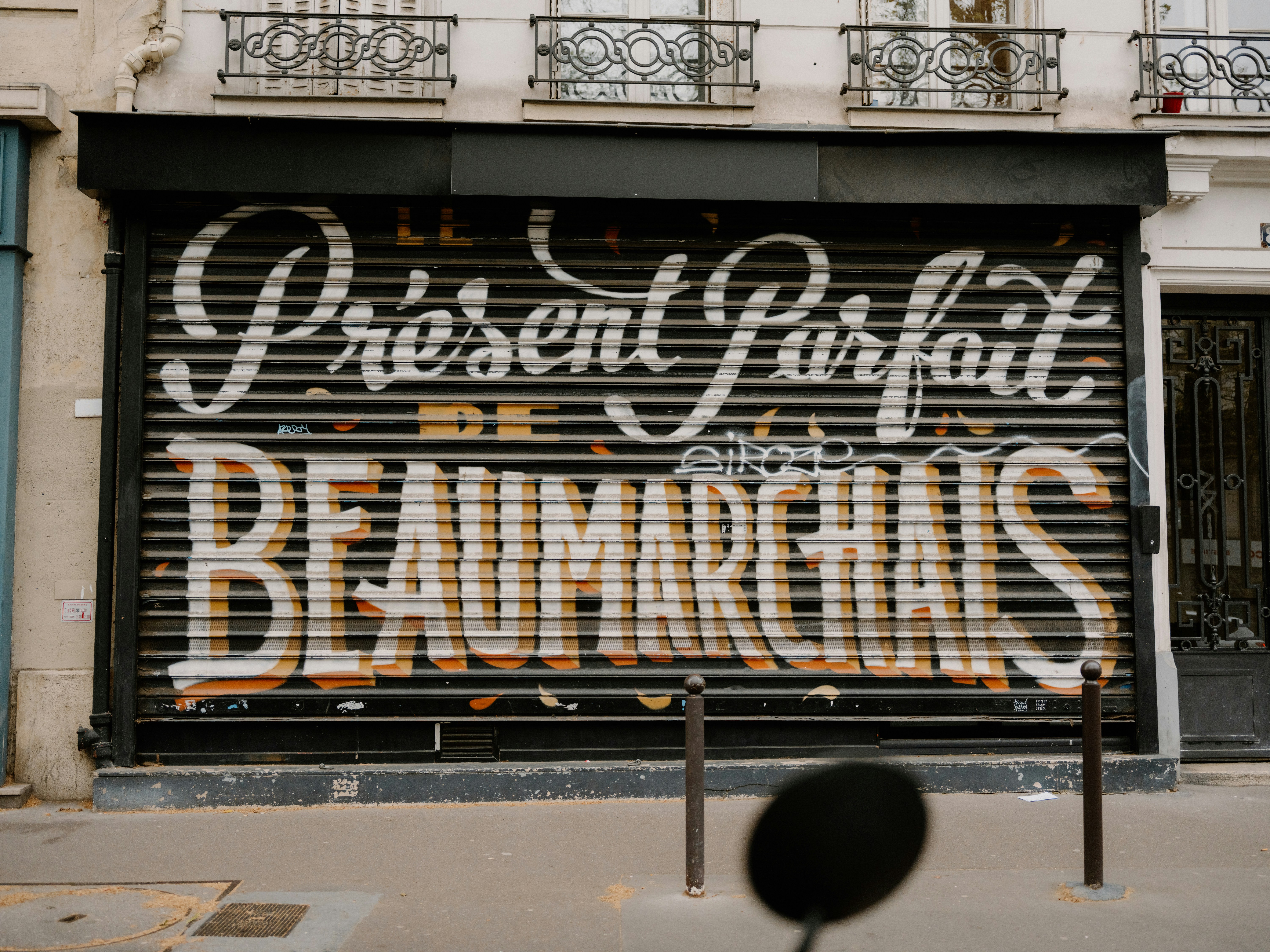 Roller shutter with "présent parfait" and "beaumarchais" text.
