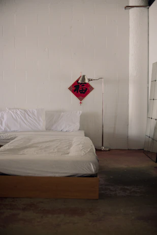 Bed with white linens and a floor lamp