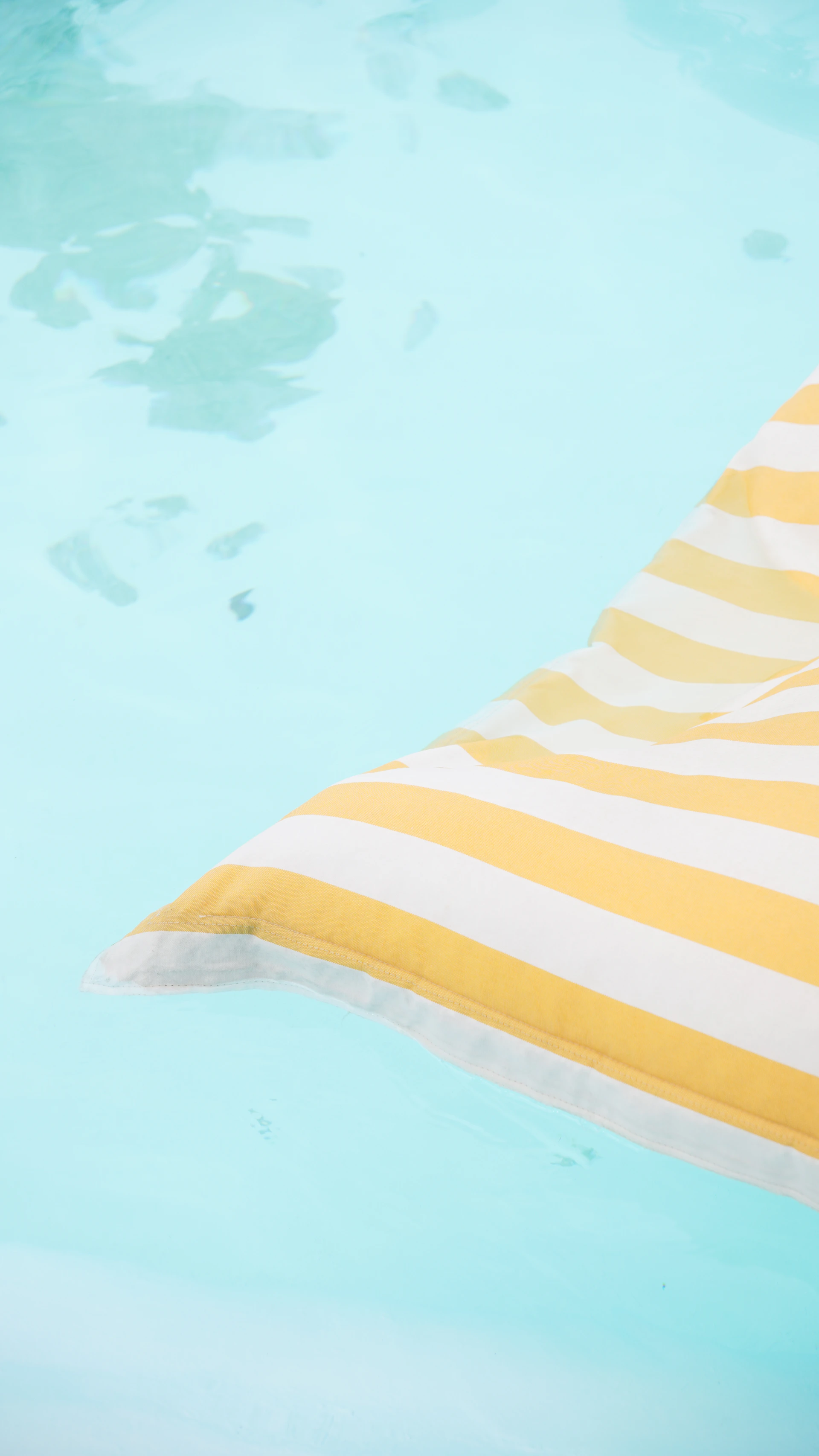 Yellow and white striped float on clear blue water
