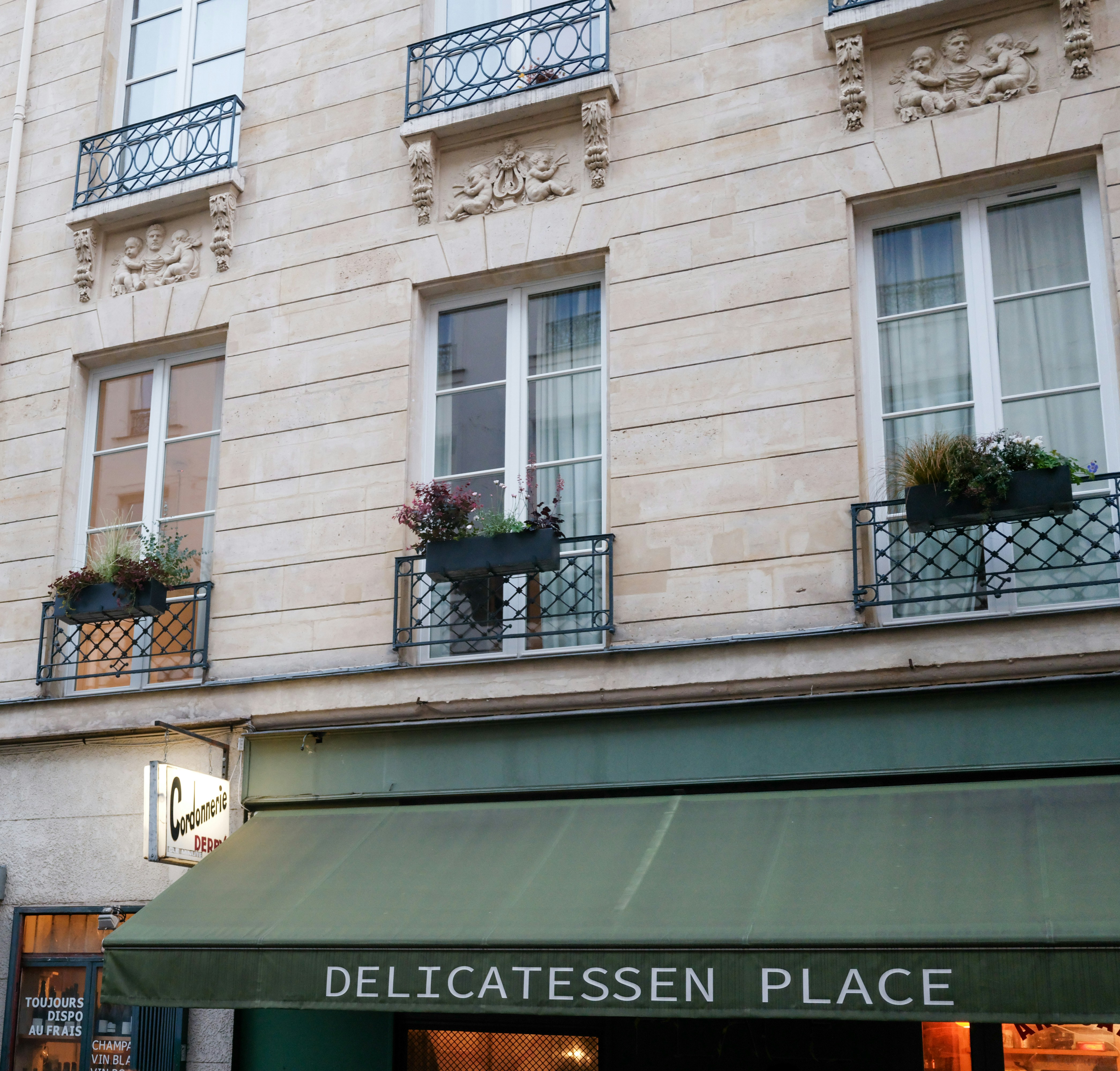 Building facade with windows and a delicatessen sign