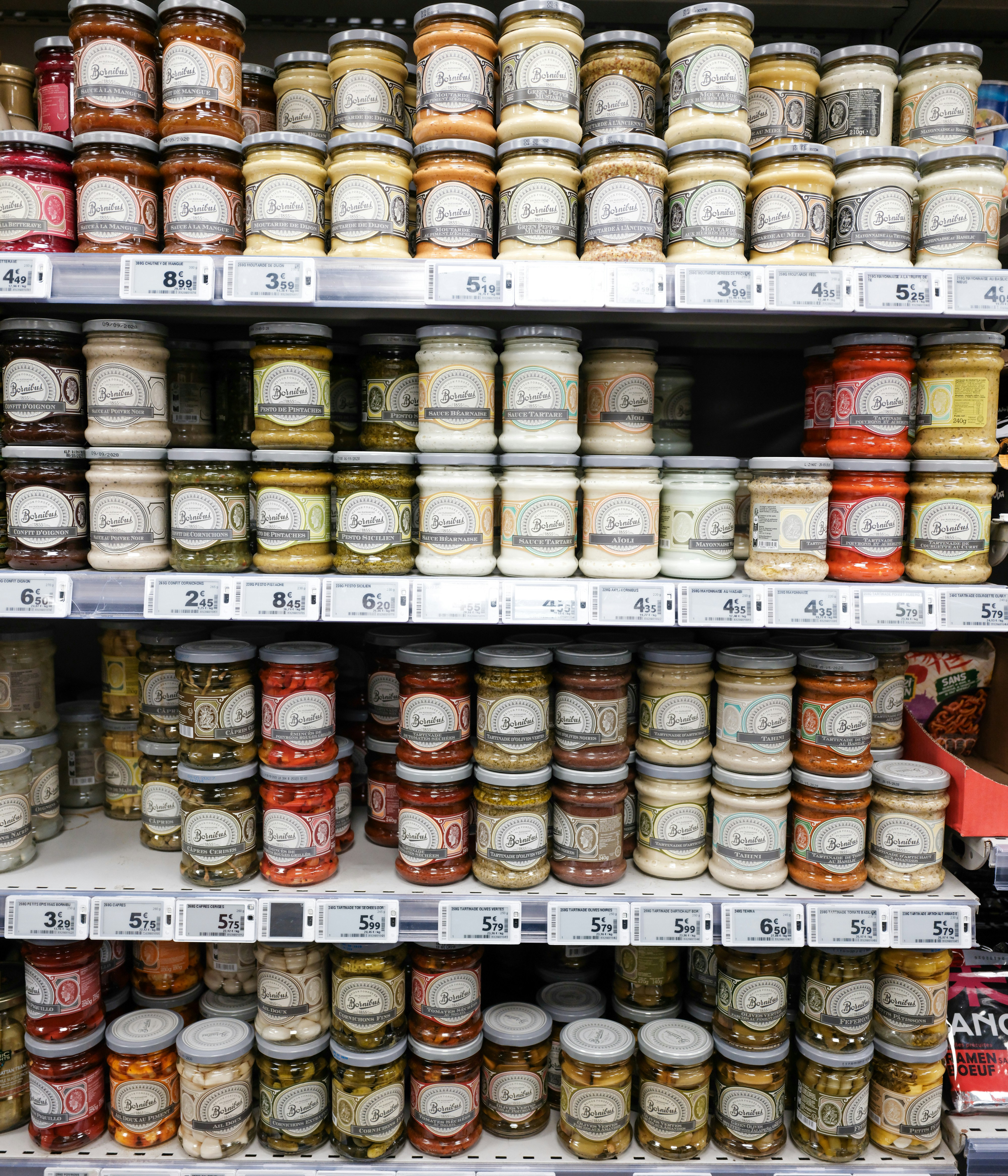 Tarros de conservas y condimentos expuestos en las estanterías del supermercado.