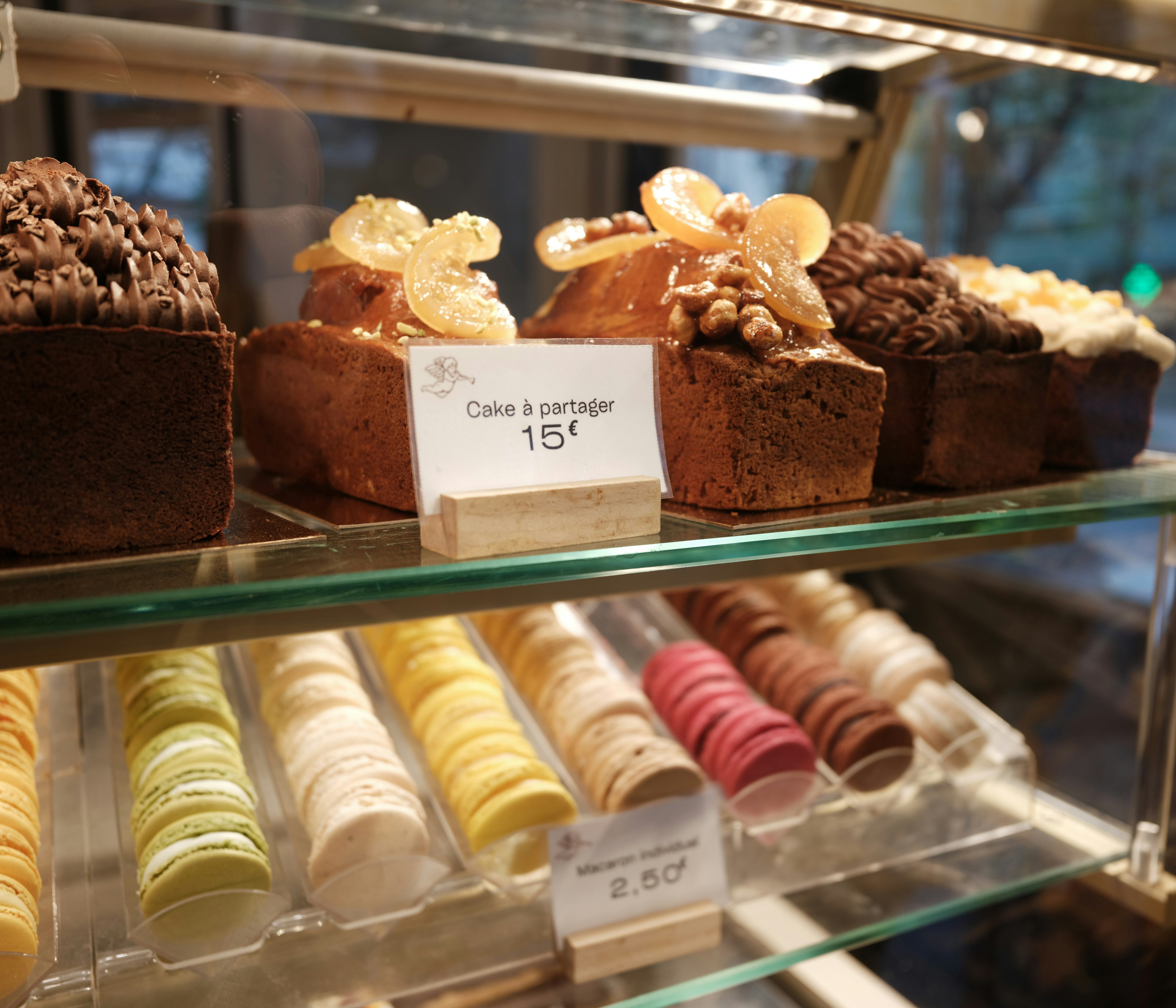 Assortment of cakes and macarons in a display case.