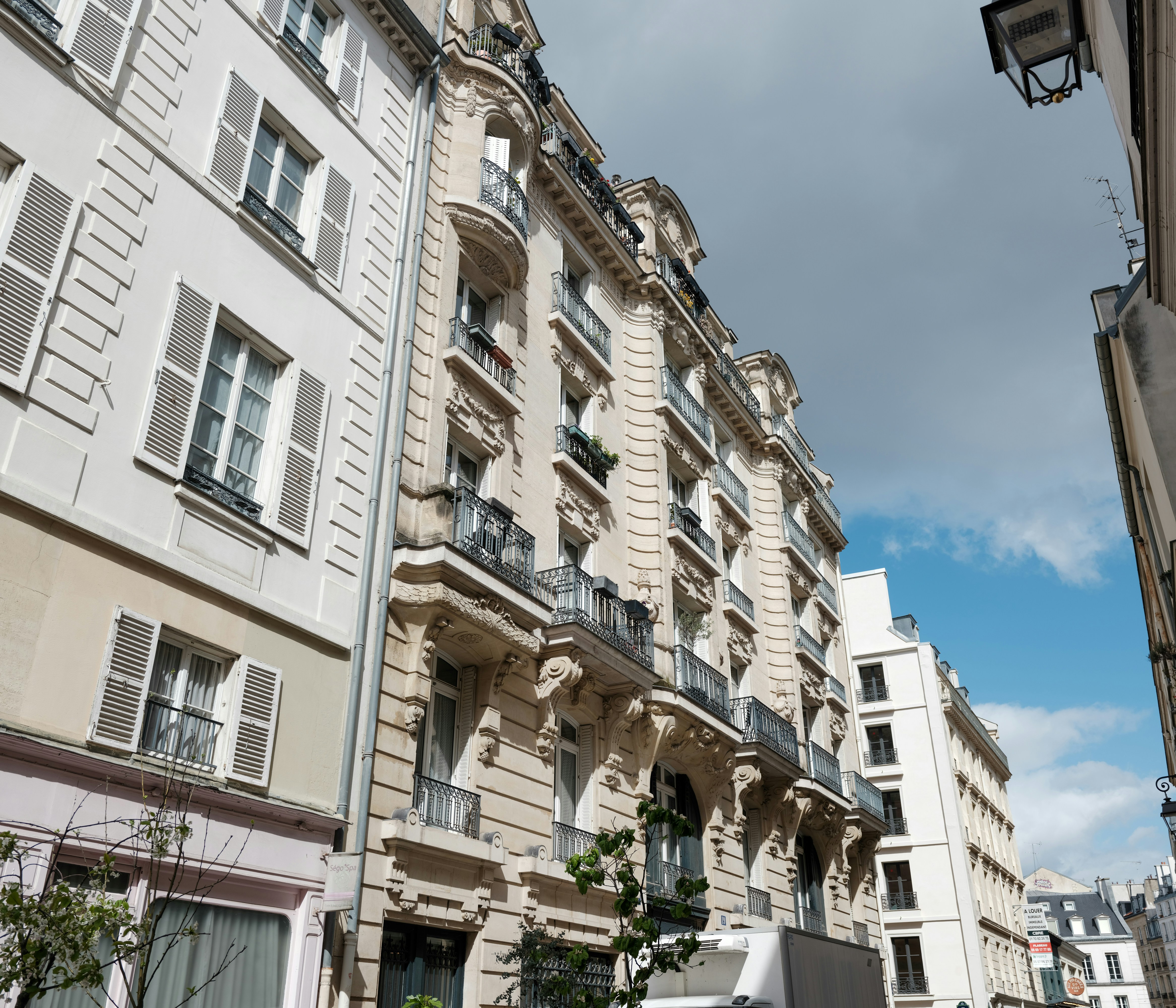 Verzierte Gebäude säumen eine schmale Pariser Straße.