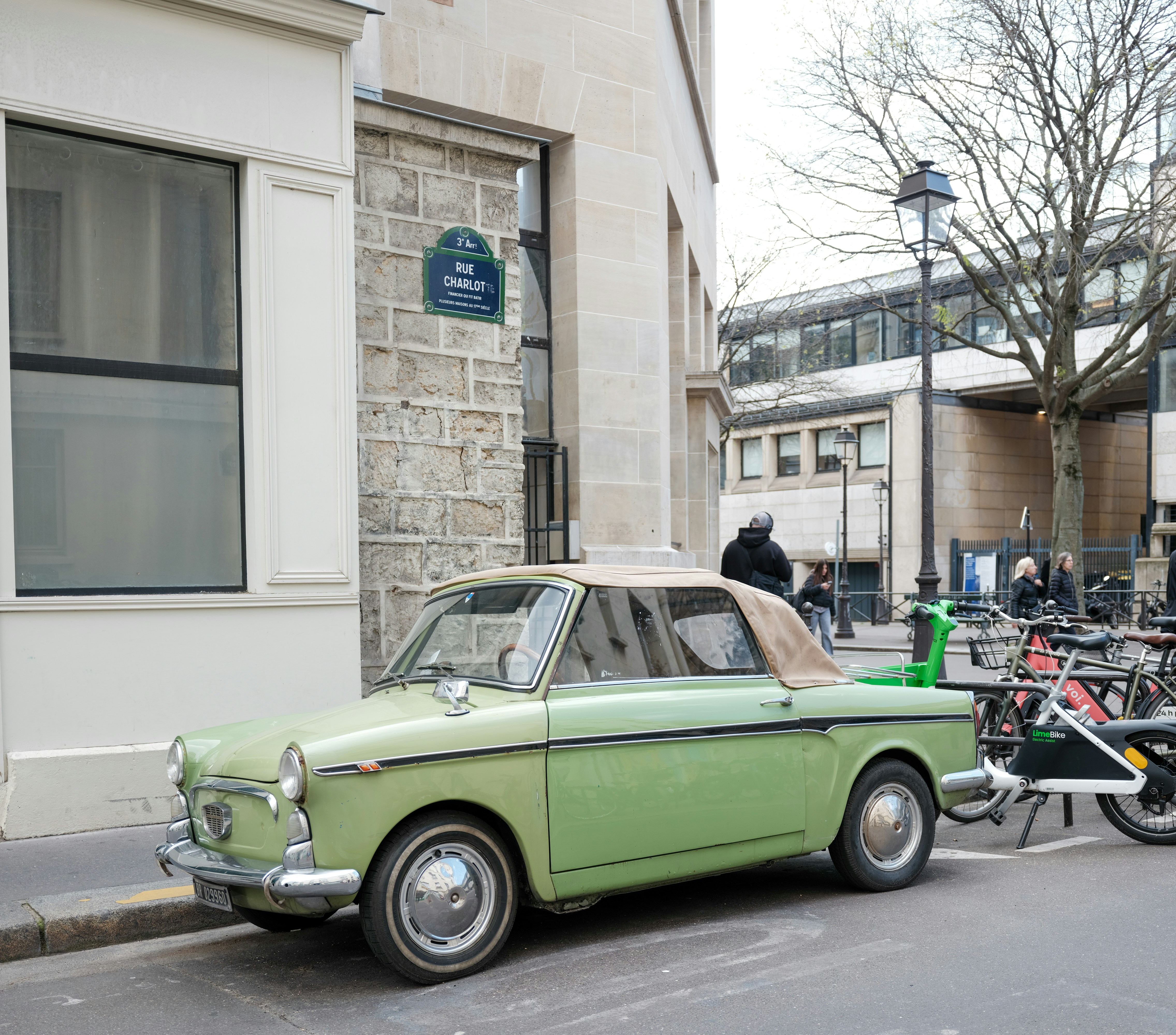 A vintage green convertible car parked on a street.