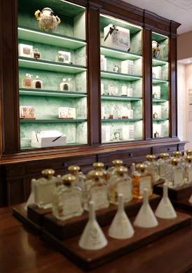 Bottles of perfume displayed on a wooden counter and shelves.