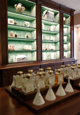 Bottles of perfume displayed on a wooden counter and shelves.