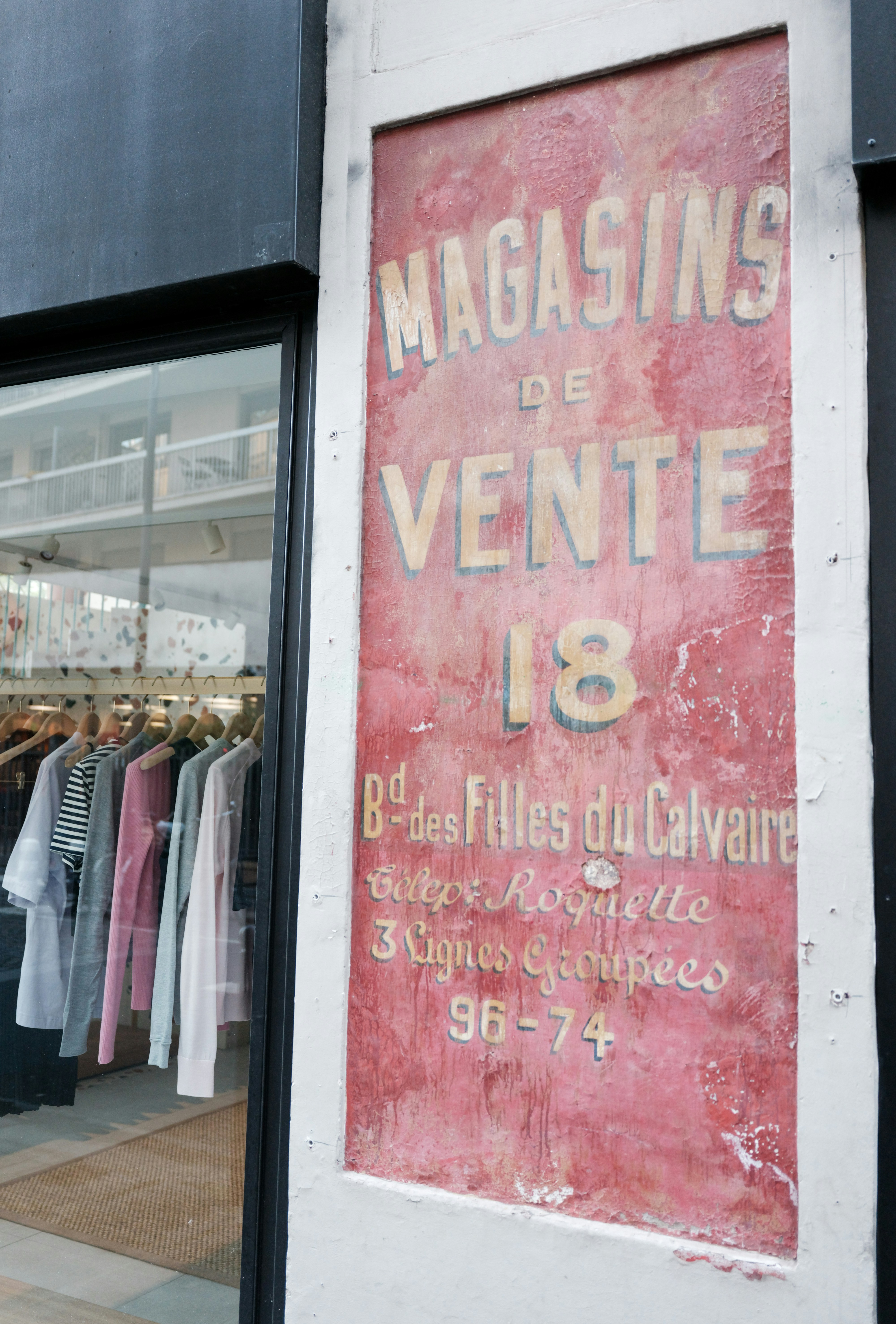 Vintage-Ladenschild mit Kleidung im Schaufenster ausgestellt