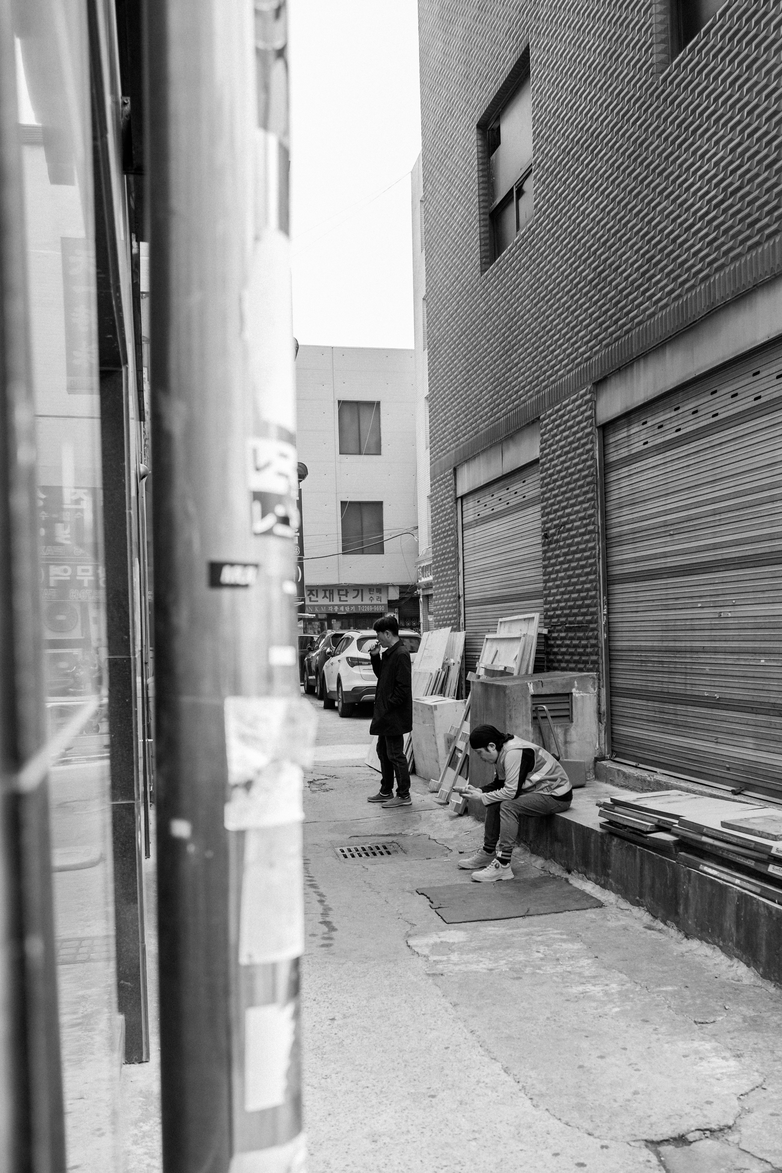 Two people in a narrow alleyway between buildings